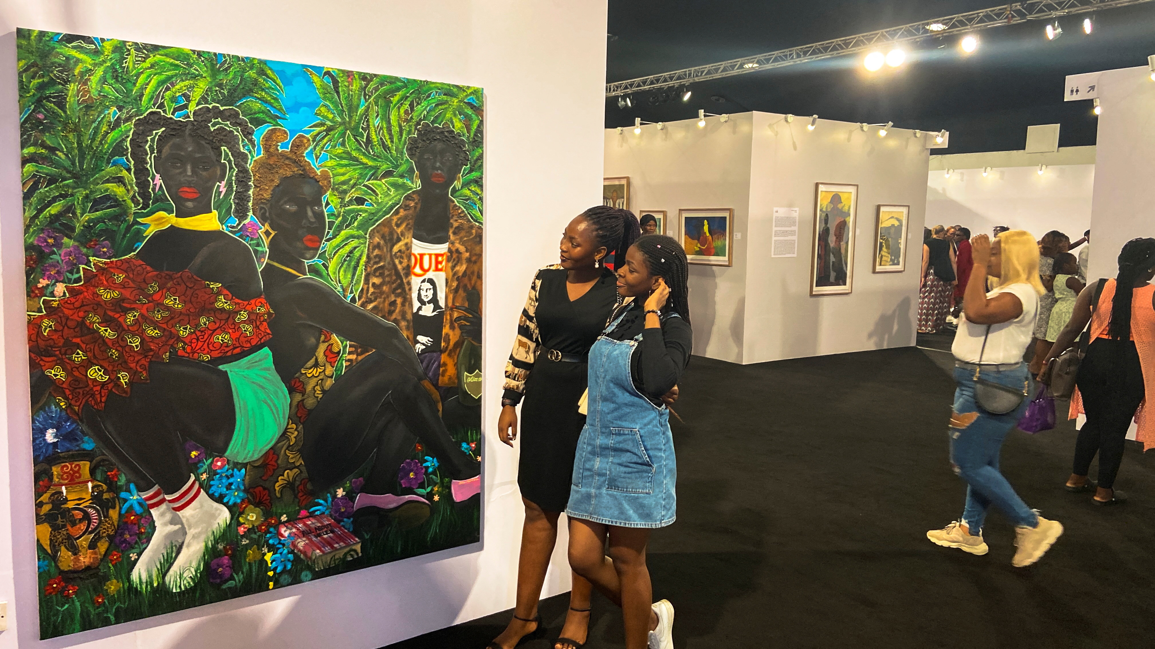 People look at a painting at the Art X, an annual art fair held in Lagos