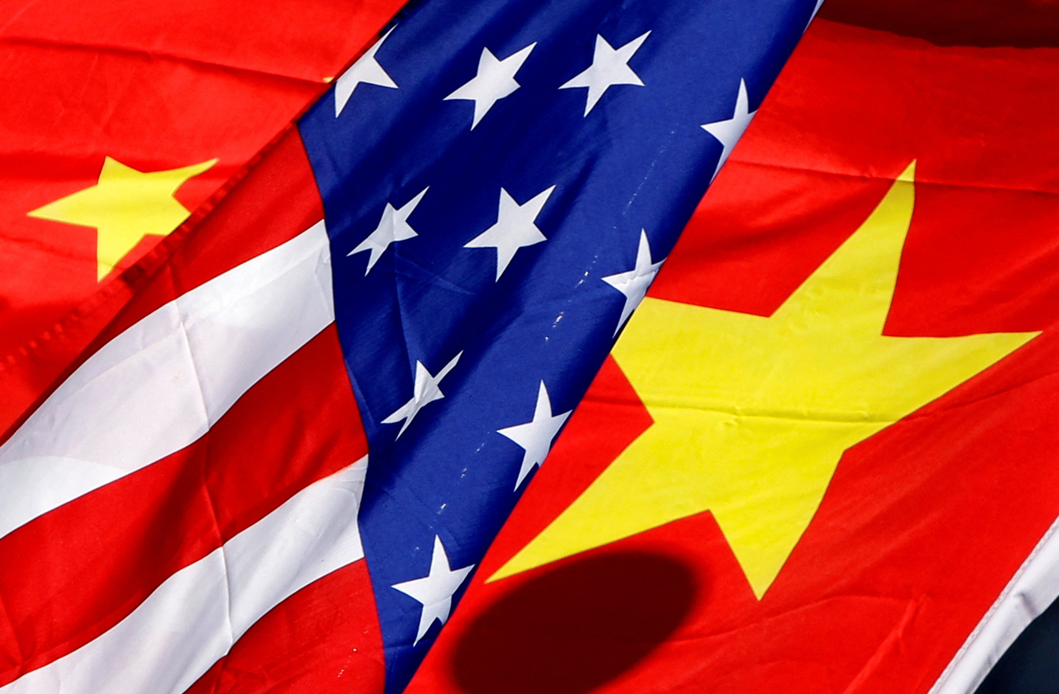 The national flags of the U.S. and China wave in front of an international hotel in Beijing
