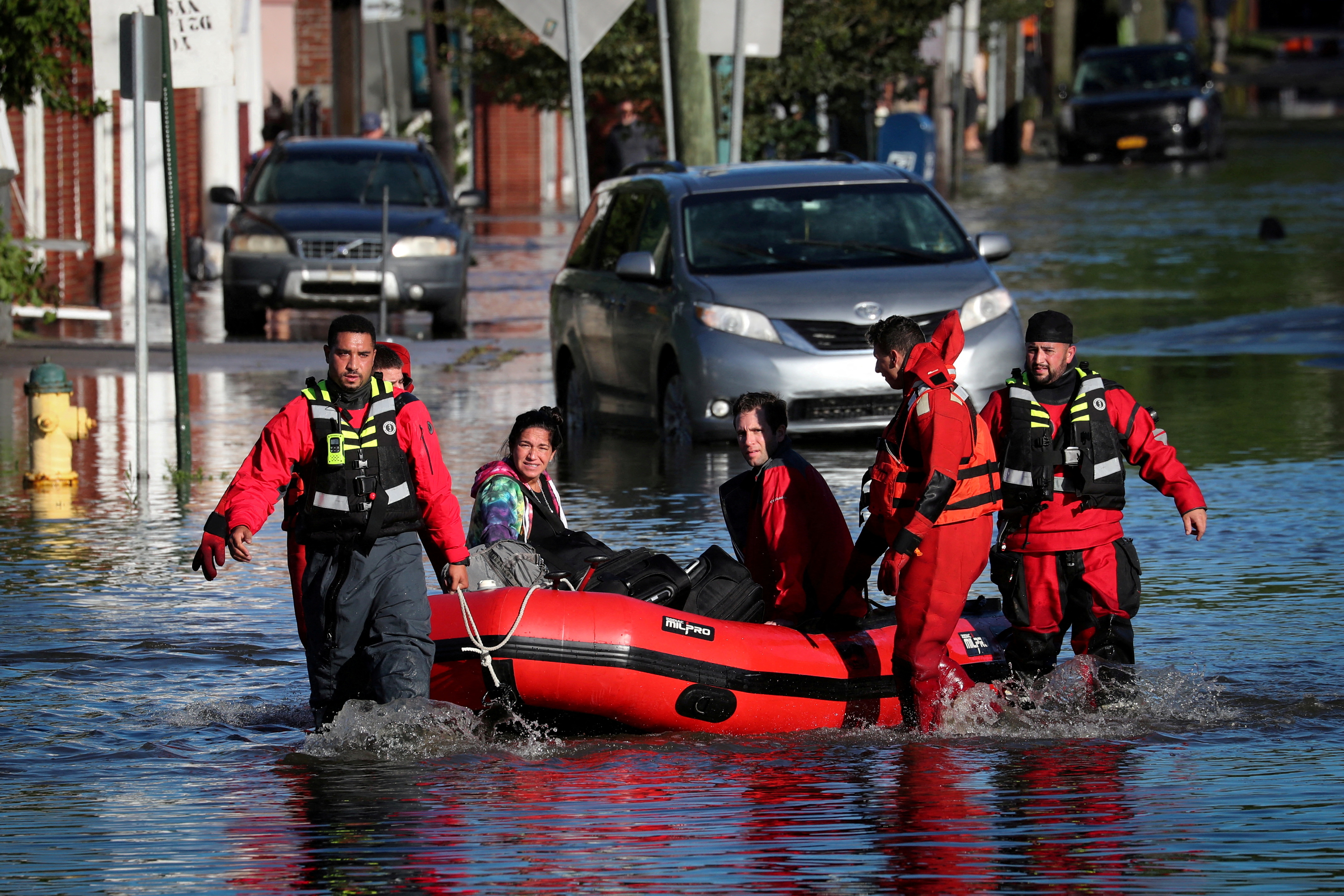 First responders pull residents in a boat following flooding in Mamaroneck, New York