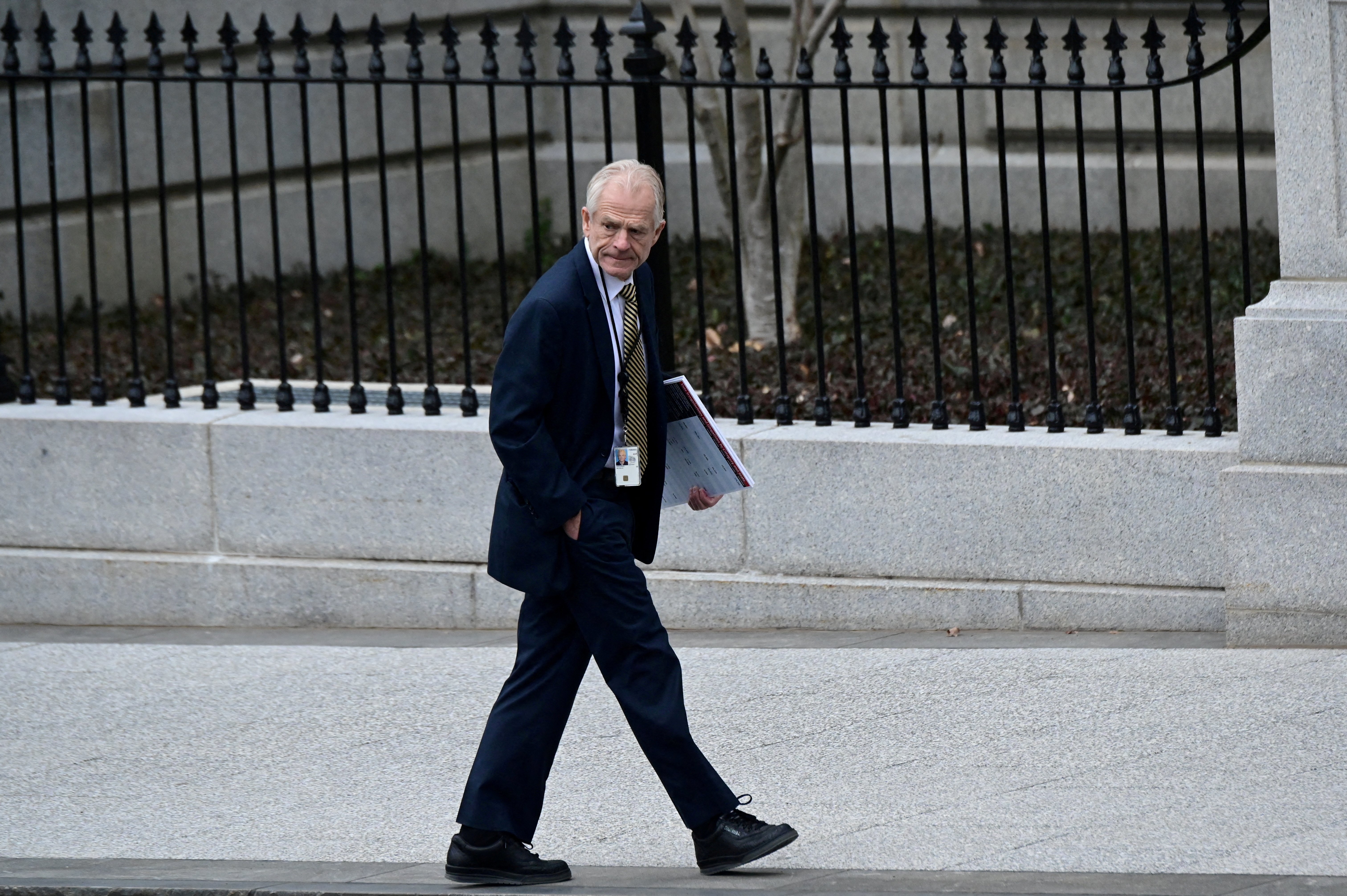 White House adviser Peter Navarro leaves the West Wing carrying a poster board displaying claims of voting irregularity at the White House in Washington