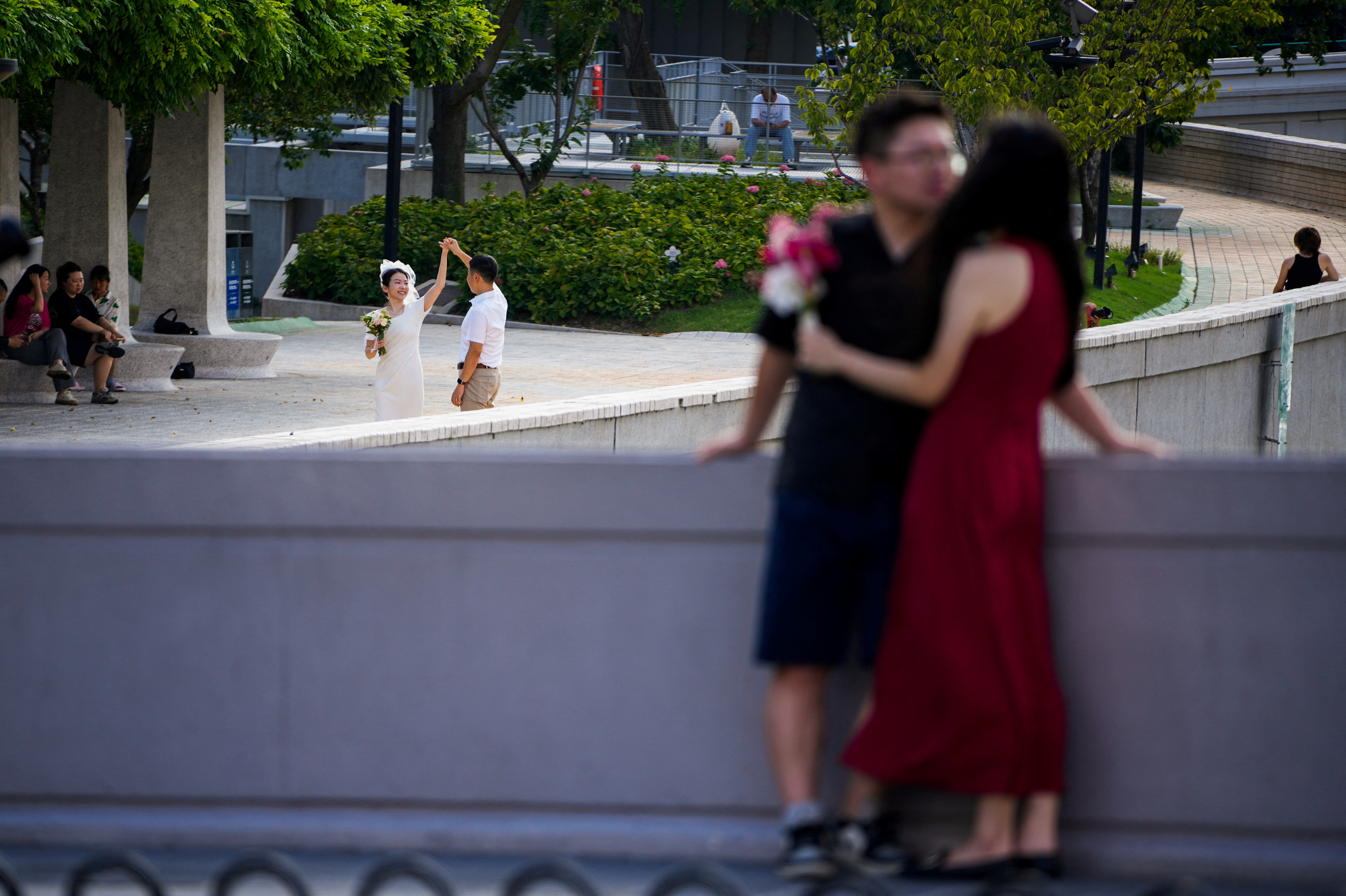 Couples prepare to get their photo taken during a wedding photography shoot on a street, in Shanghai