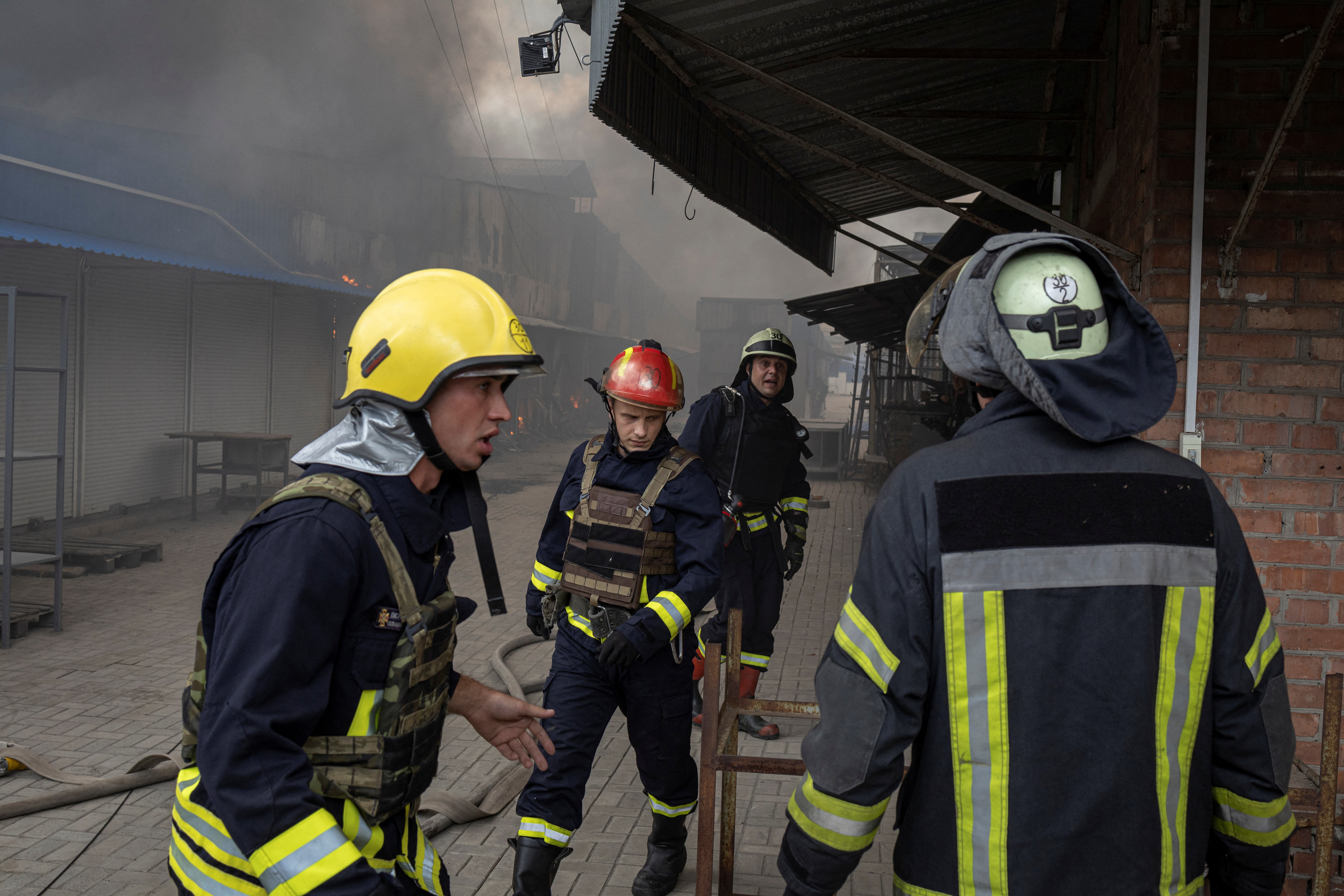 Firefighters spray water onto fire at market after shelling in Sloviansk