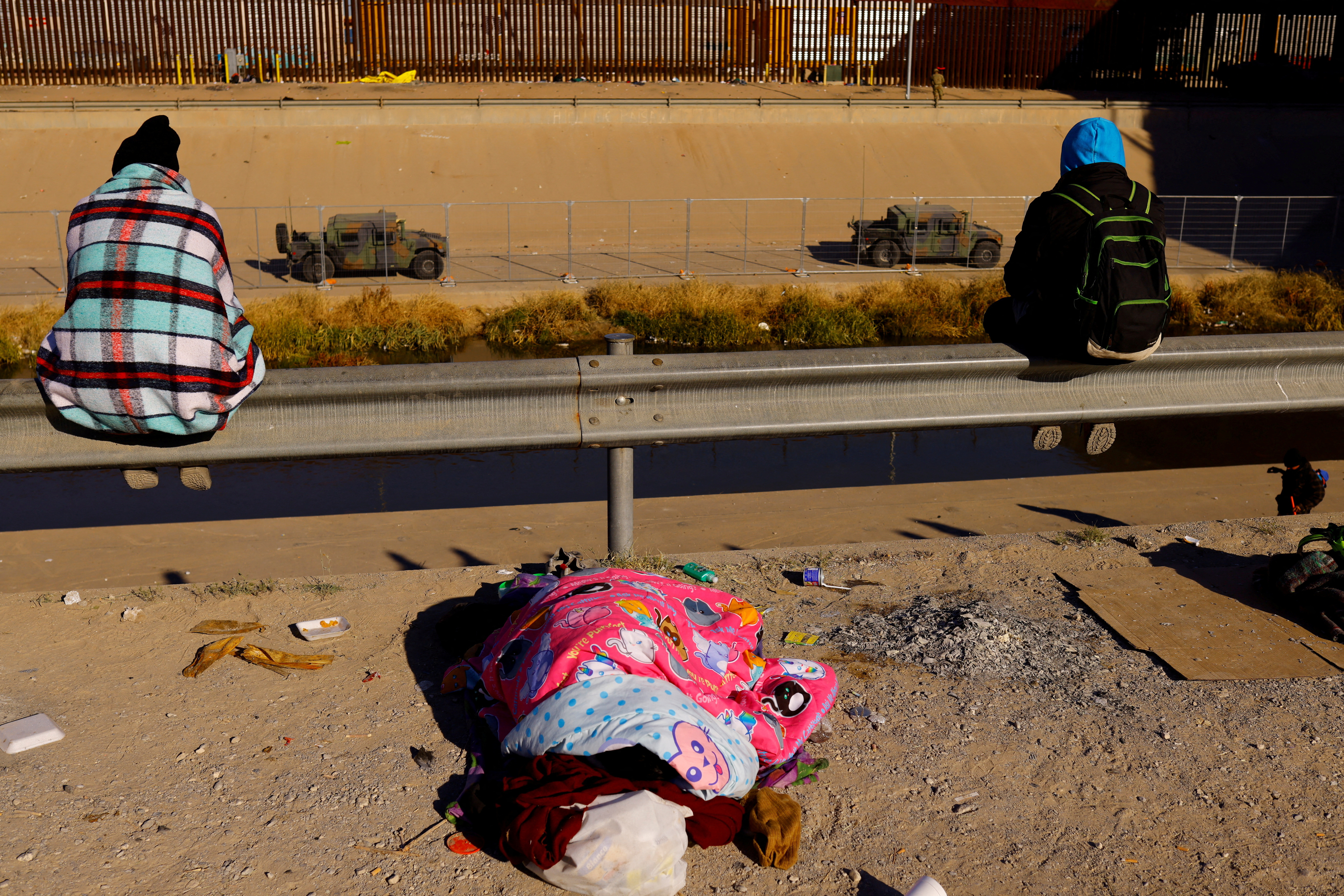 Asylum-seeking migrants rest near the Rio Bravo river, in Ciudad Juarez