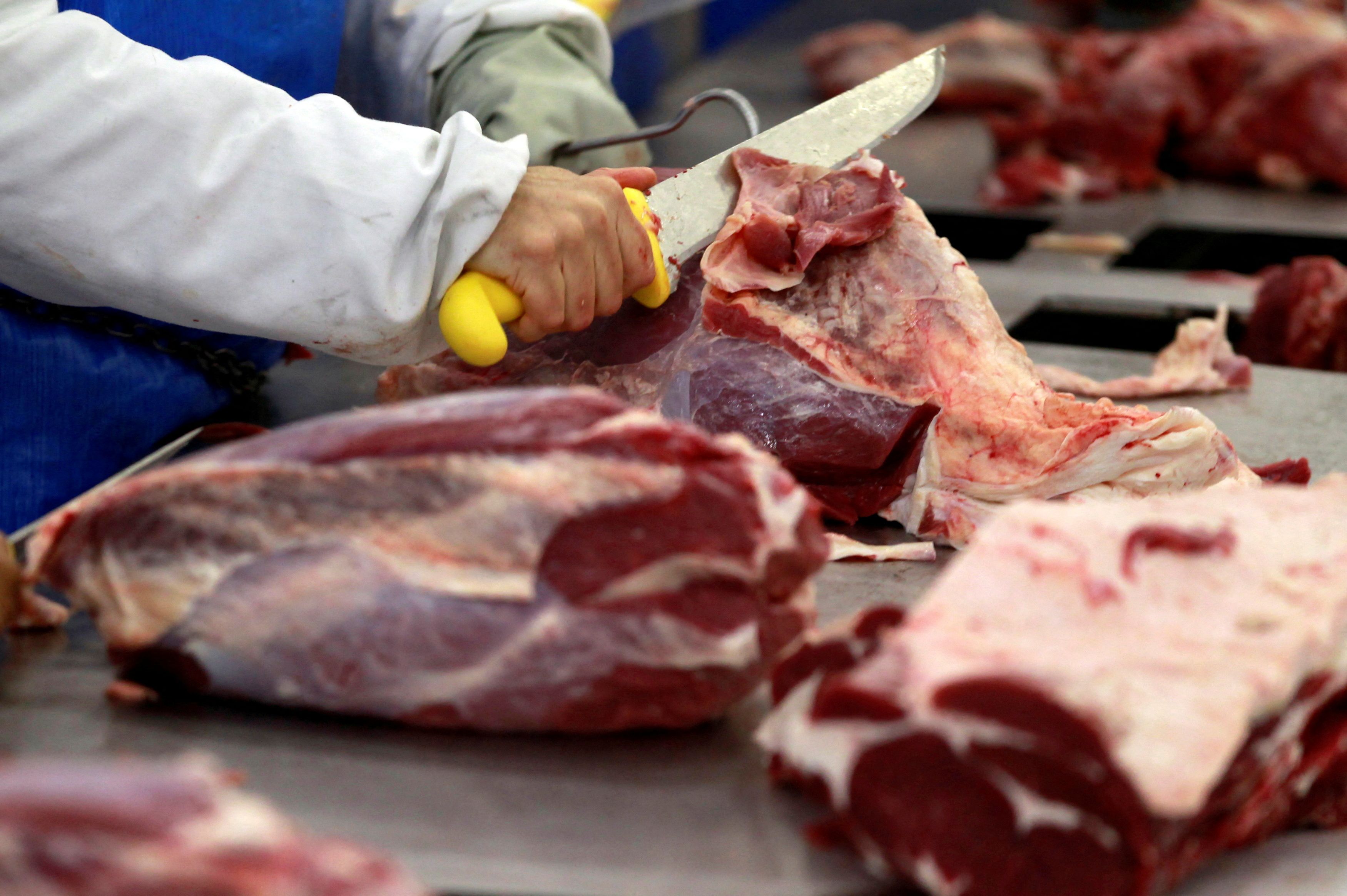 A worker cuts up joints of beef at the Marfrig Group slaughterhouse in Promissao
