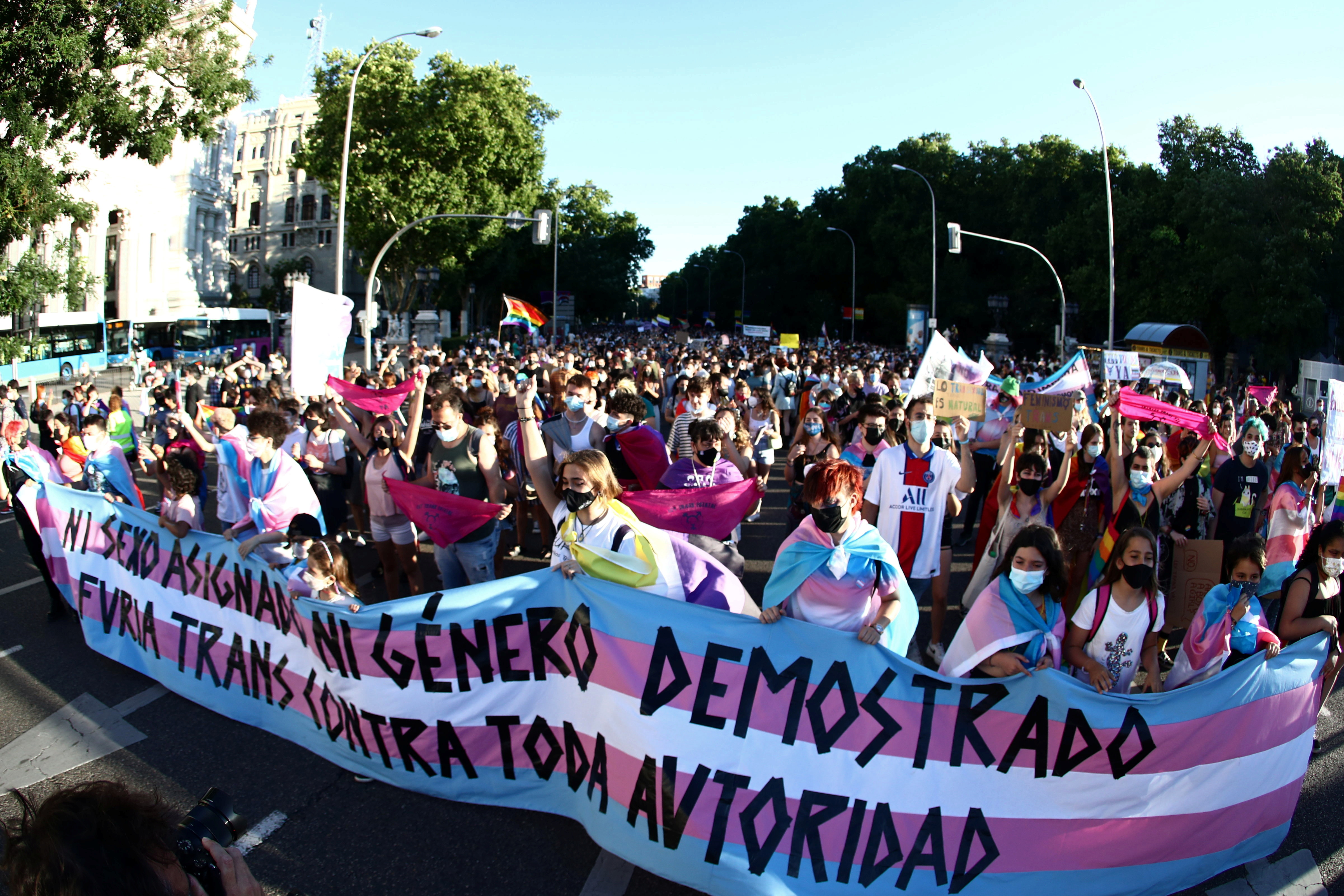 People hold a banner with the colours of the transgender movement as they take part in protest to mark LGBT Pride Day in Madrid, Spain, June 28, 2021. REUTERS/Sergio Perez