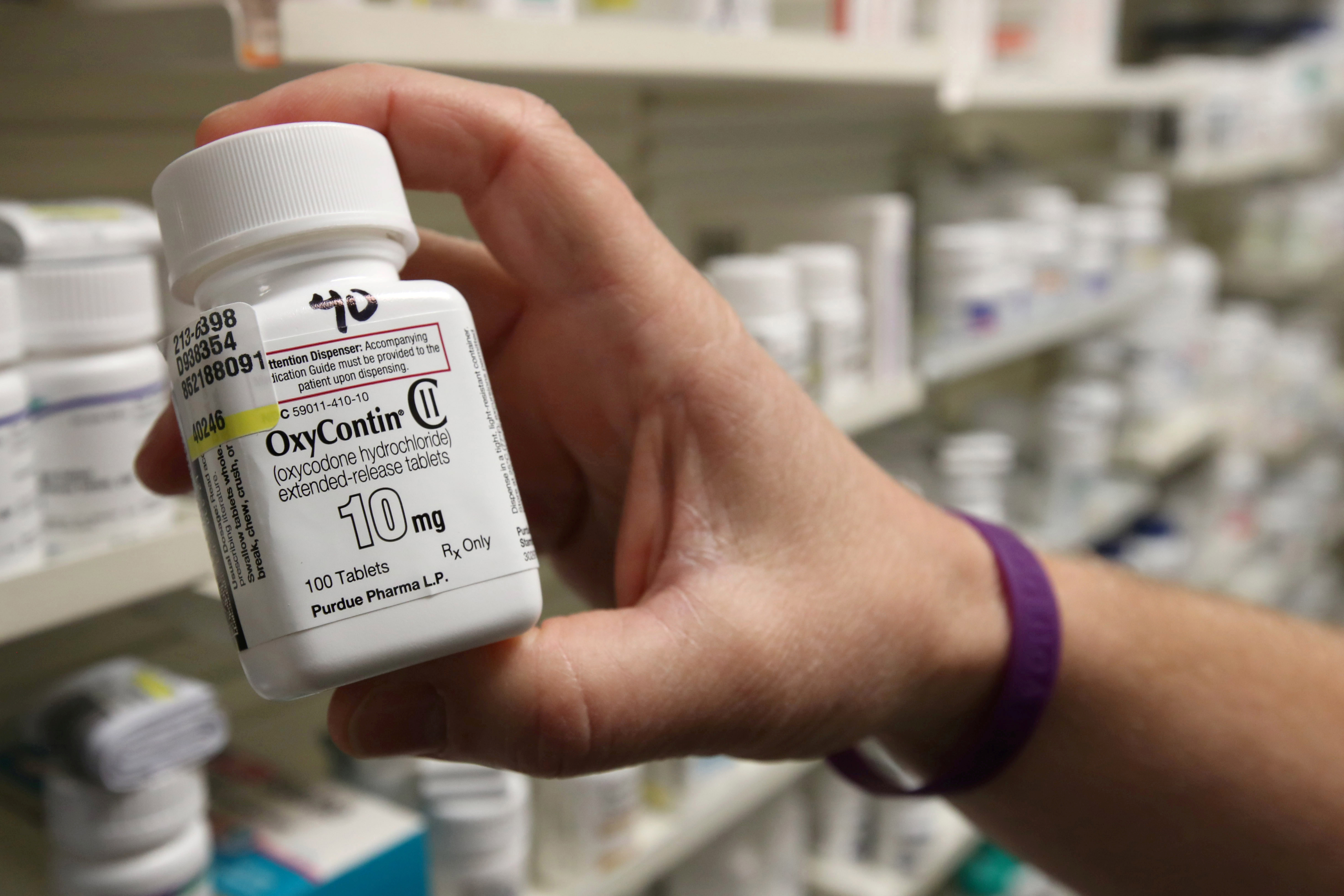 A pharmacist holds a bottle OxyContin made by Purdue Pharma at a pharmacy in Provo, Utah