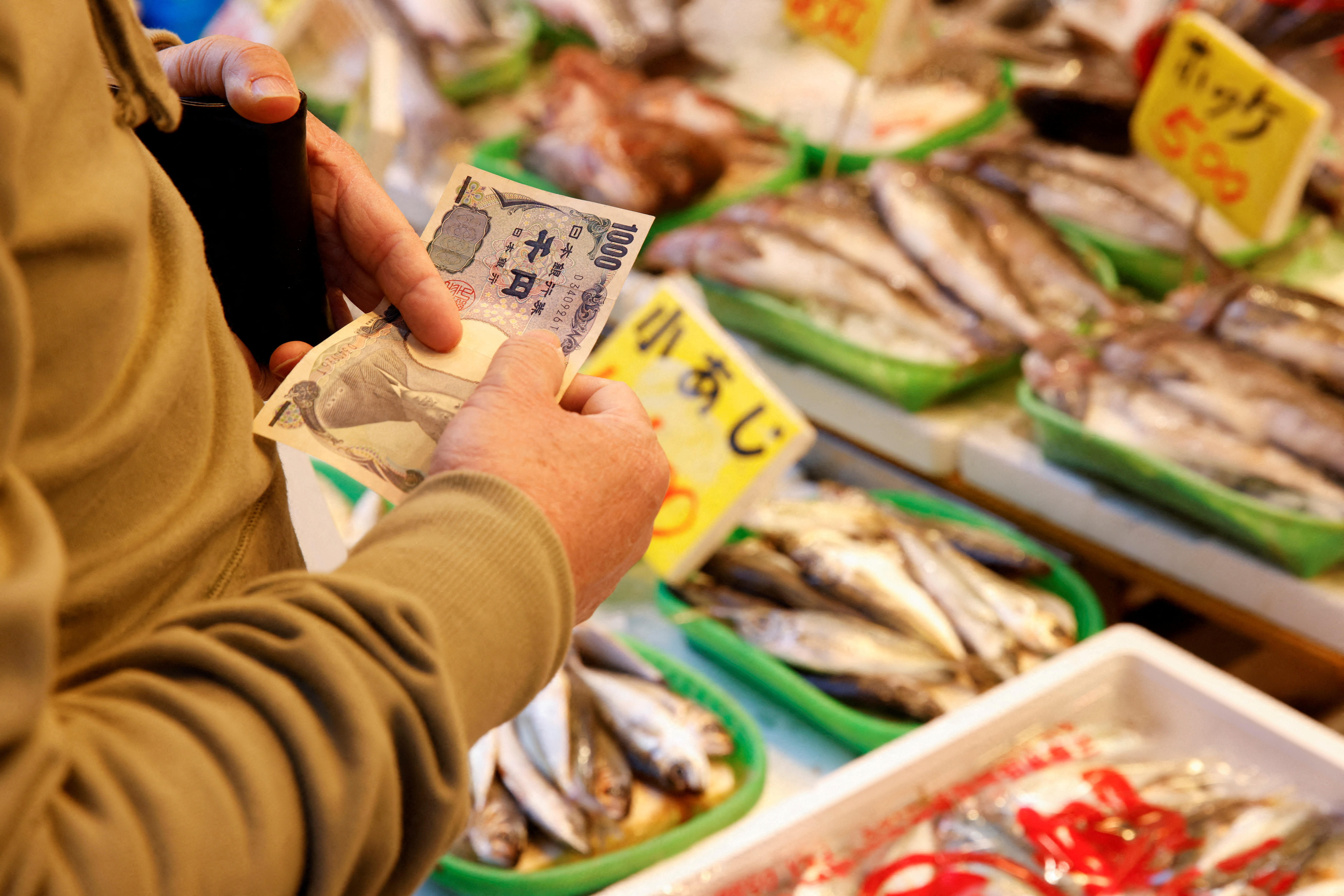 Man buys fish at a market in Tokyo