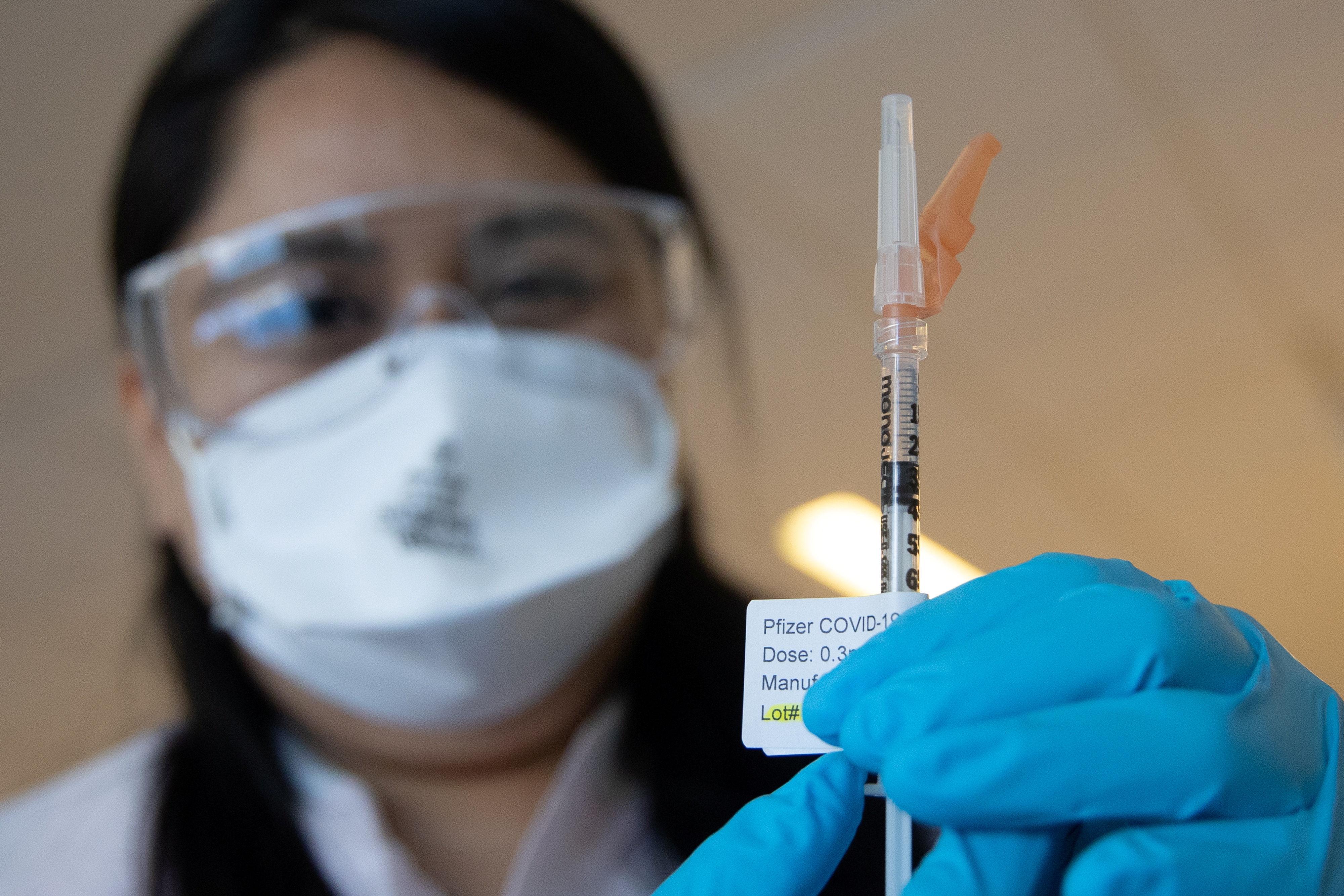 A nurse Cindy Mendez wearing a protective mask holds a syringe with a dose of the Pfizer-BioNTech COVID-19 vaccine during the coronavirus disease (COVID-19) pandemic, at NYC Health + Hospitals Harlem Hospital in the Manhattan borough of New York City, New York, U.S., February 25, 2021. REUTERS/Jeenah Moon