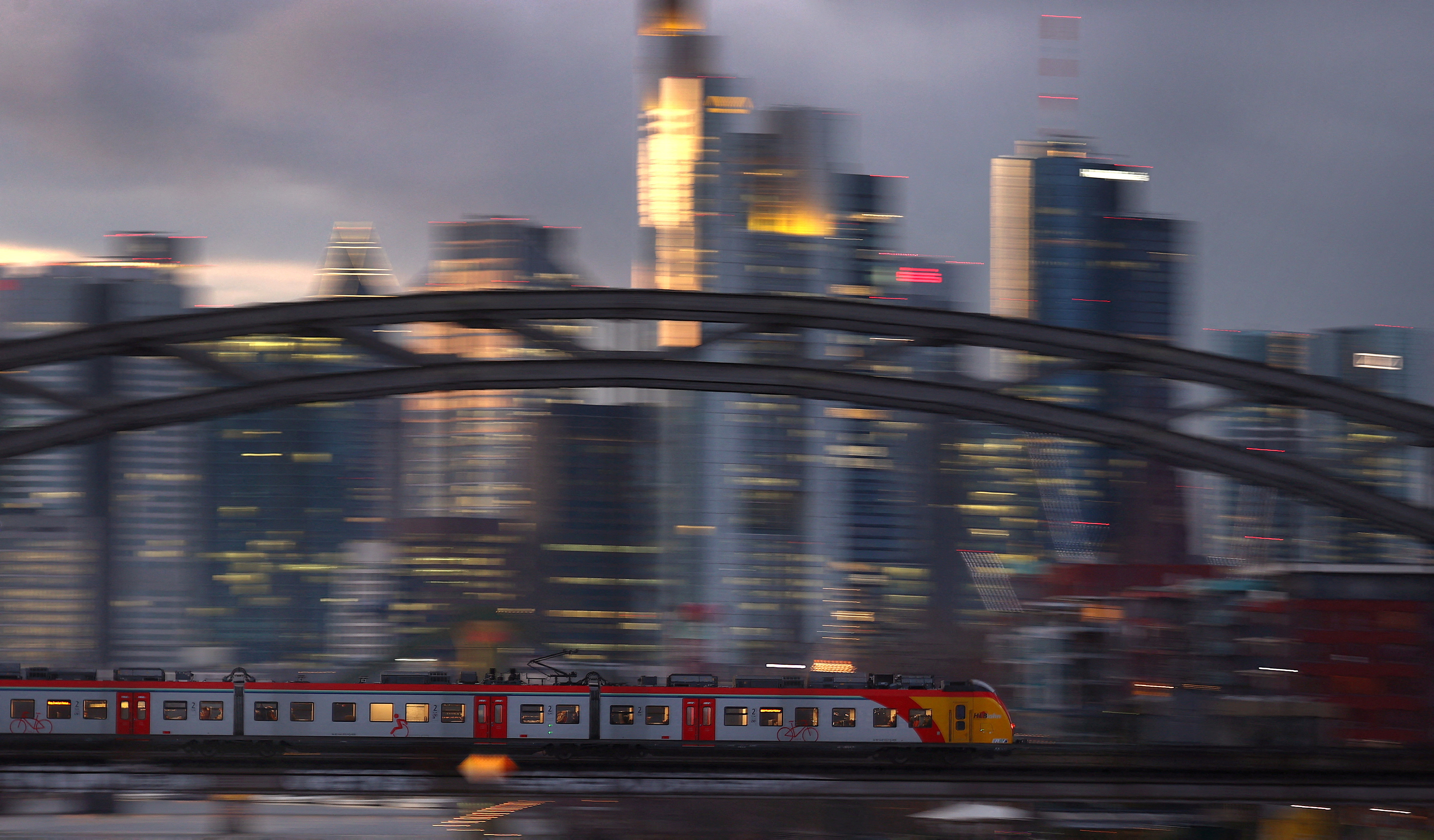 A commuter train passes the skyline in a slow shutter speed photograph in Frankfurt