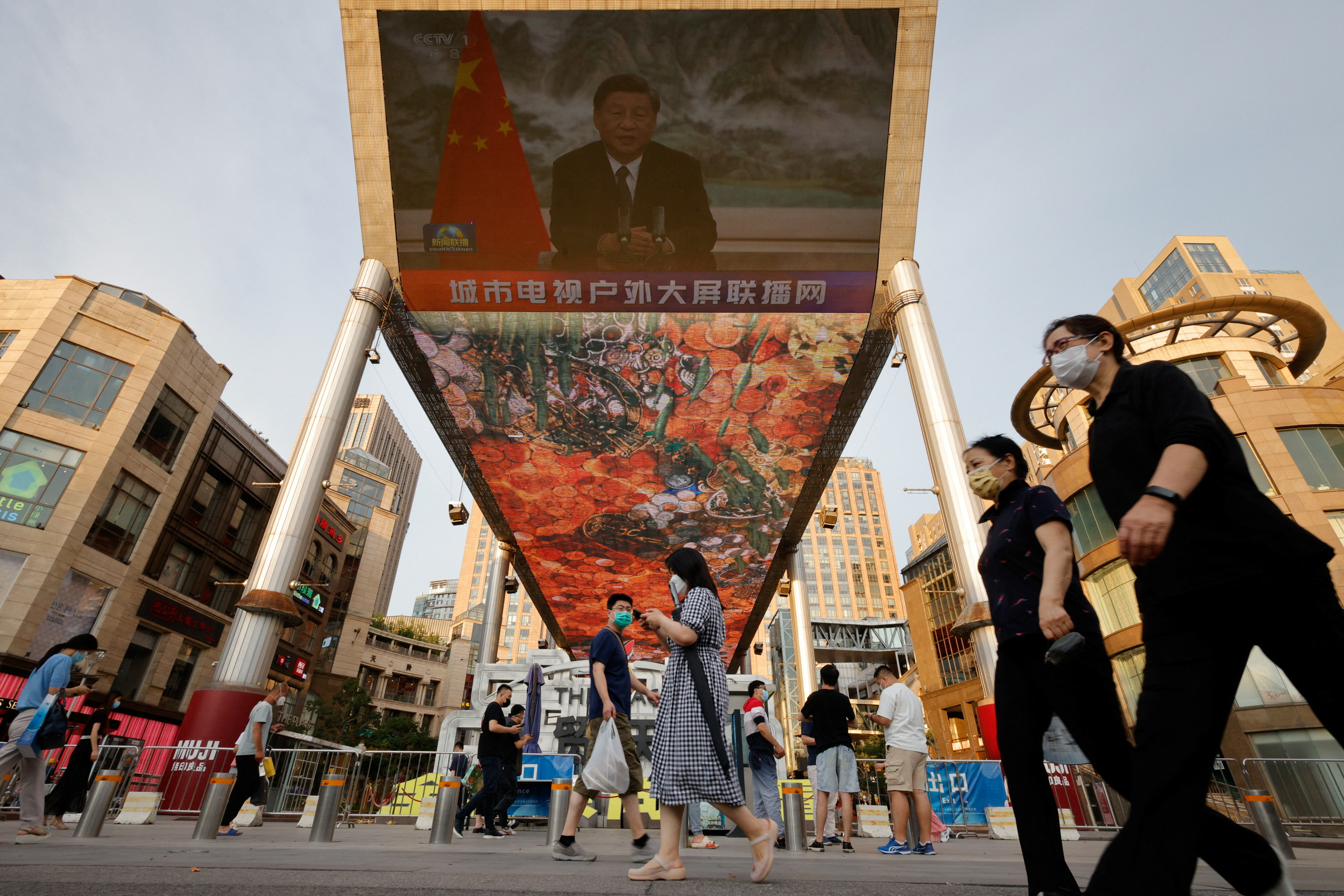 A screen shows a CCTV state media news broadcast of Chinese President Xi Jinping, addressing the BRICS Business Forum via video link, at a shopping center in Beijing