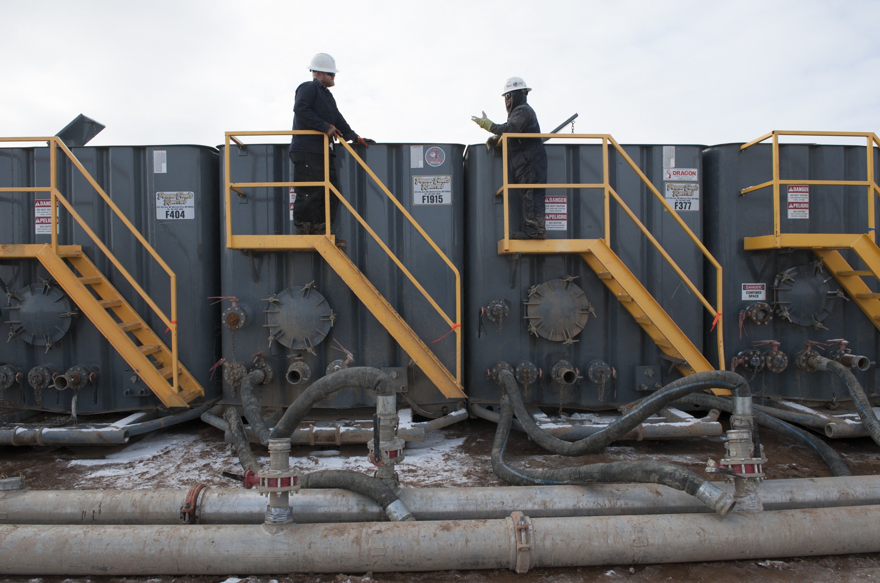 A worker monitors water tanks at a Hess fracking site near Williston