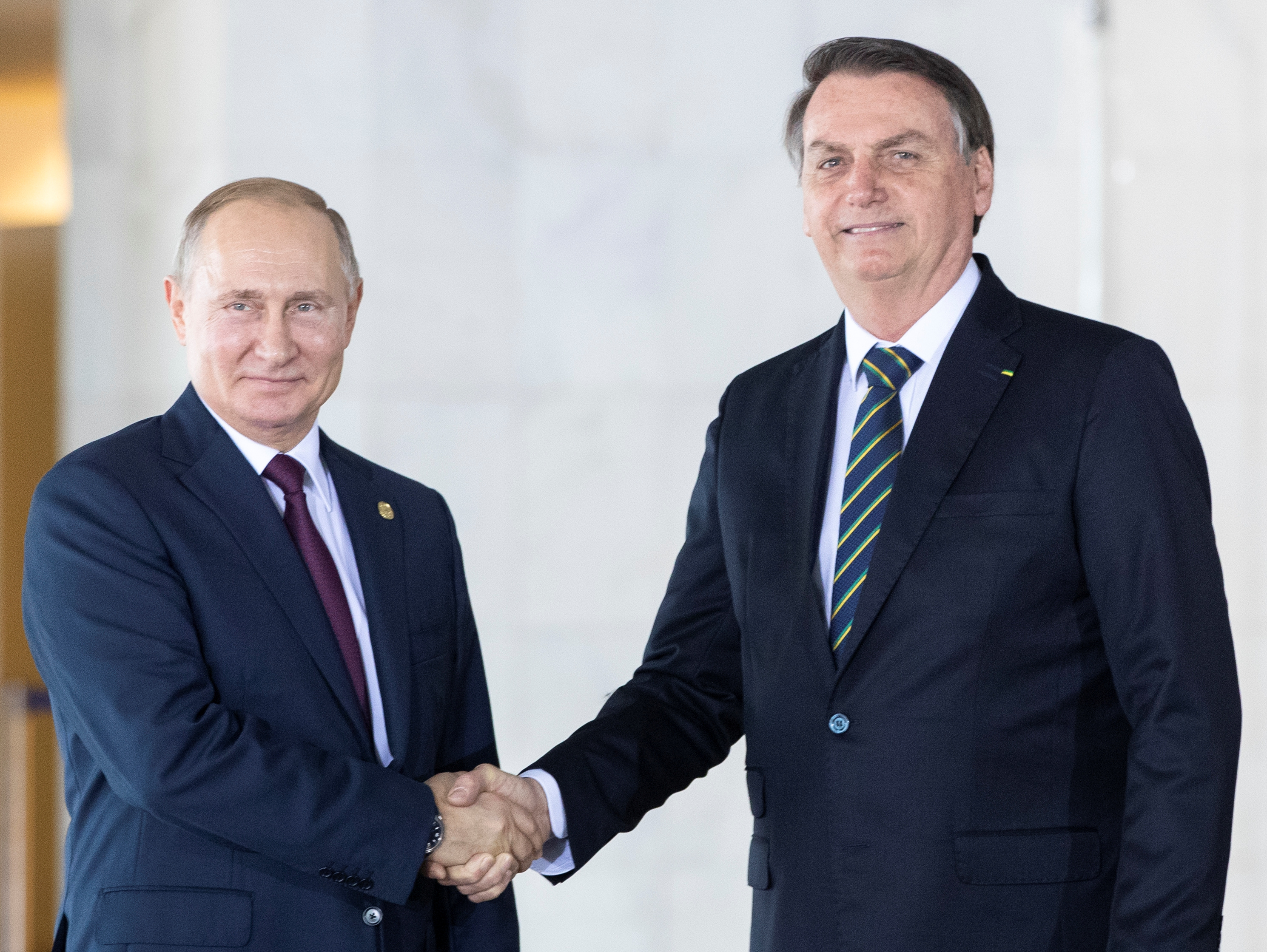 Brazil's President Jair Bolsonaro welcomes Russia's President Vladimir Putin to a meeting of leaders of the BRICS emerging economies at the Itamaraty palace in Brasilia