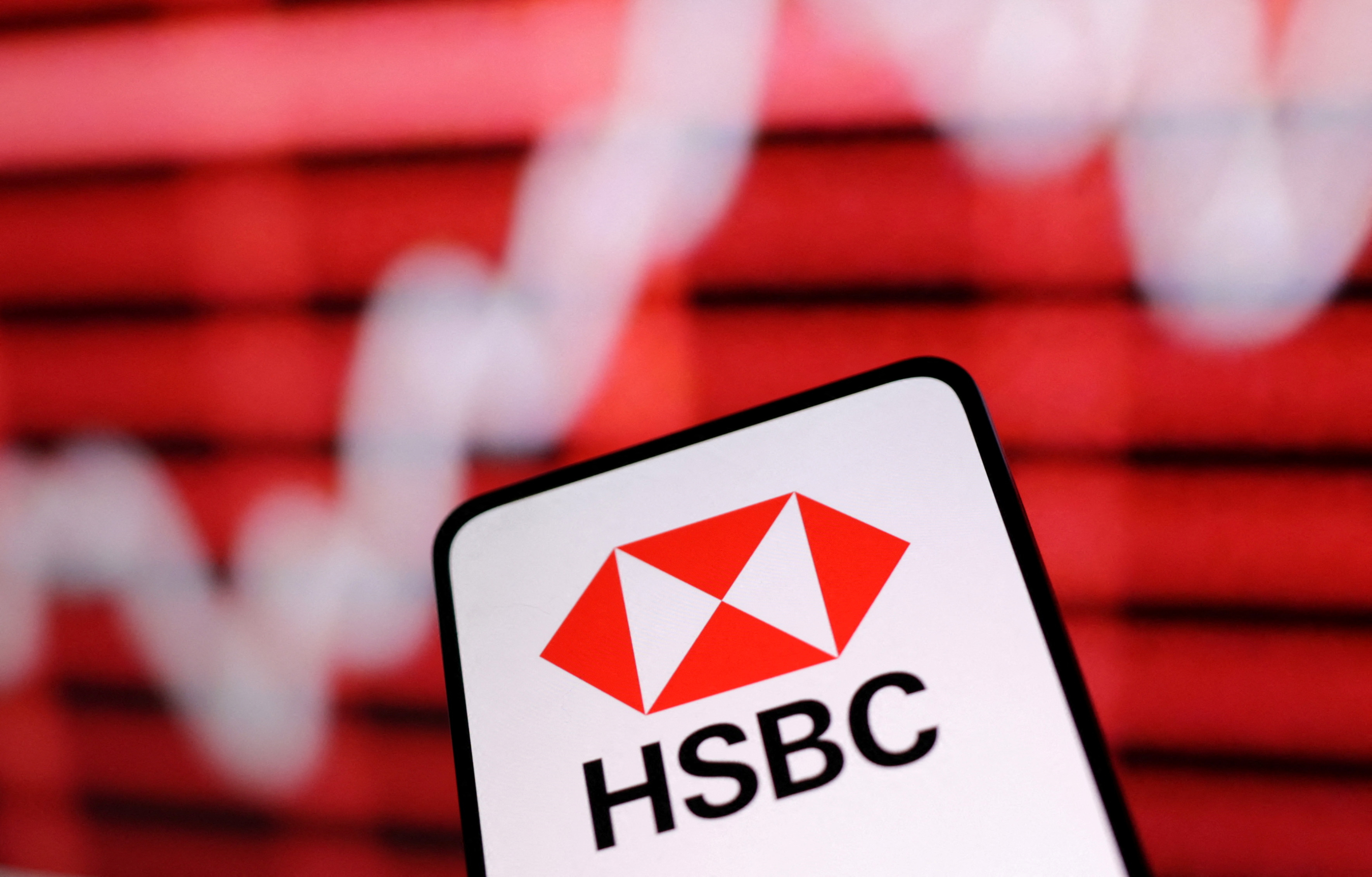 Illustration shows HSBC Bank logo and rising stock graph