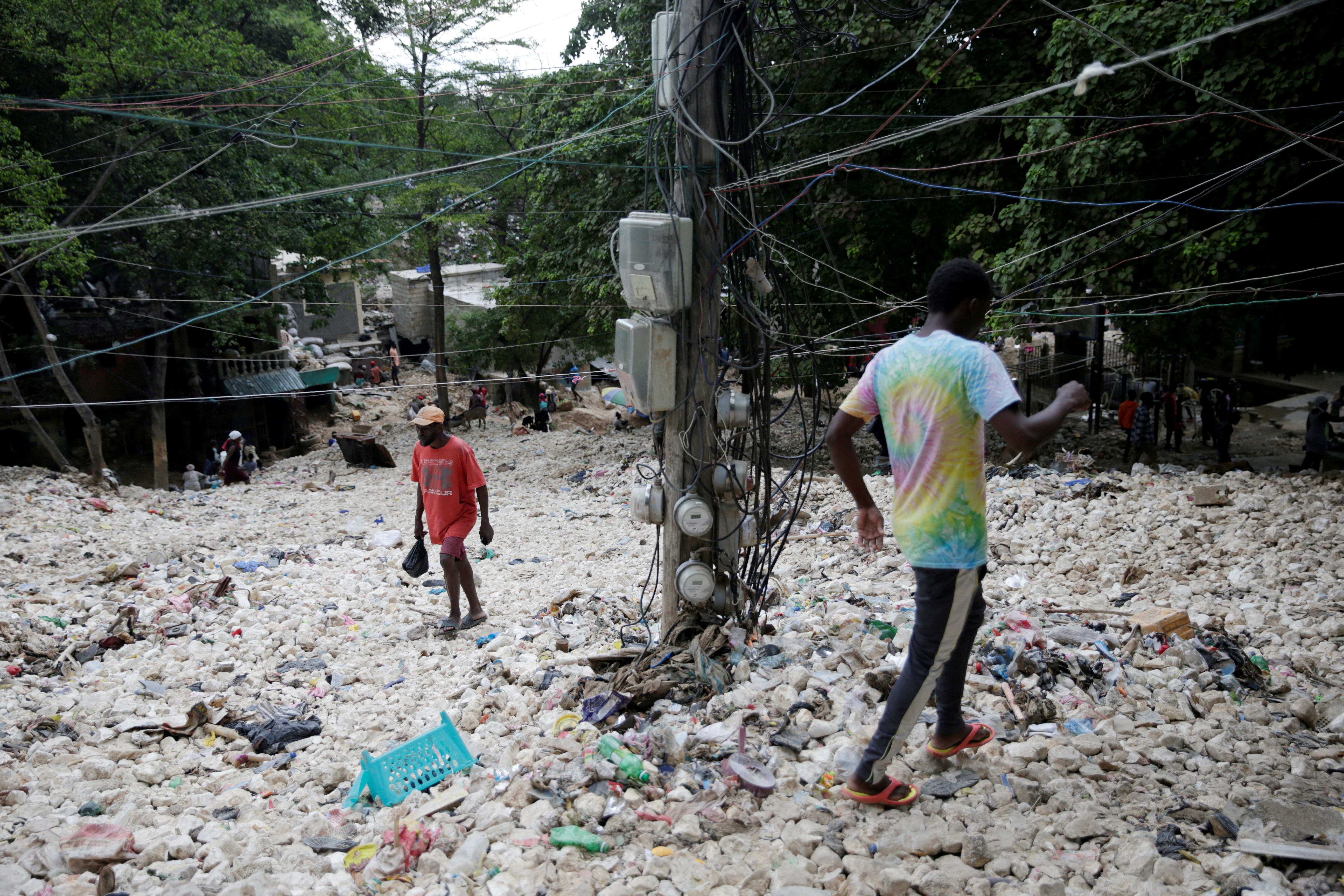 People walk along an area affected by the passage of Tropical Storm Laura, in Port-au-Prince