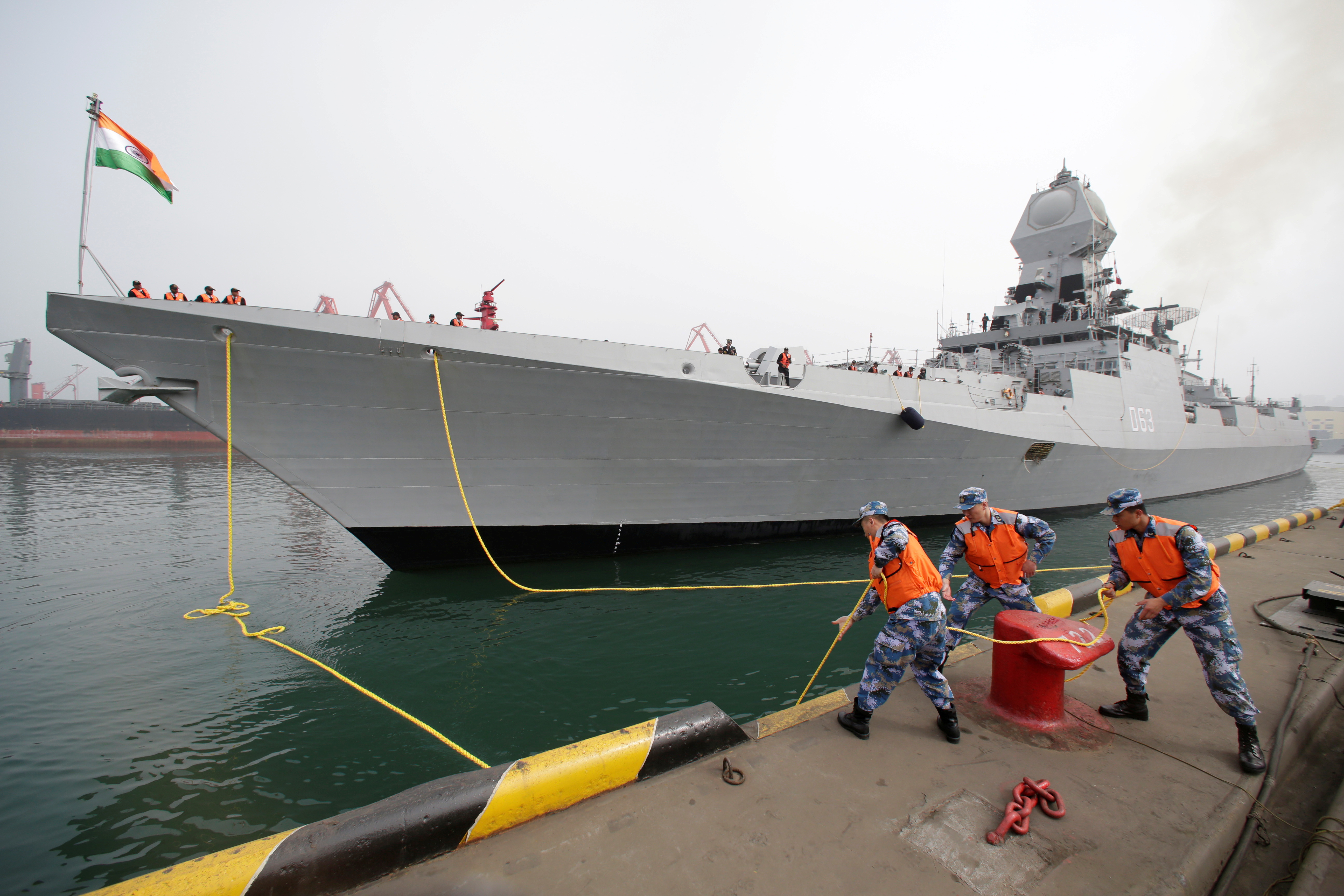 Chinese navy personnel moor the Indian Navy warship INS Kolkata at Qingdao Port for the 70th anniversary celebrations of the founding of the Chinese People's Liberation Army Navy (PLAN), in Qingdao