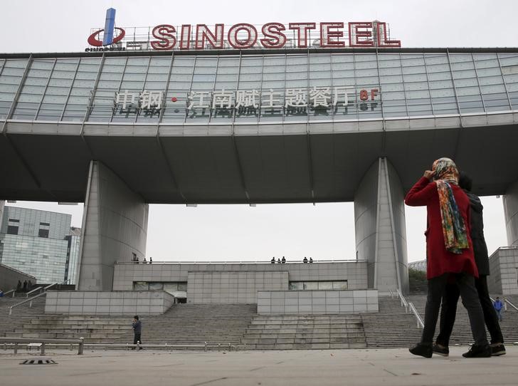 Workers walk past Sinosteel's headquarter building in Beijing