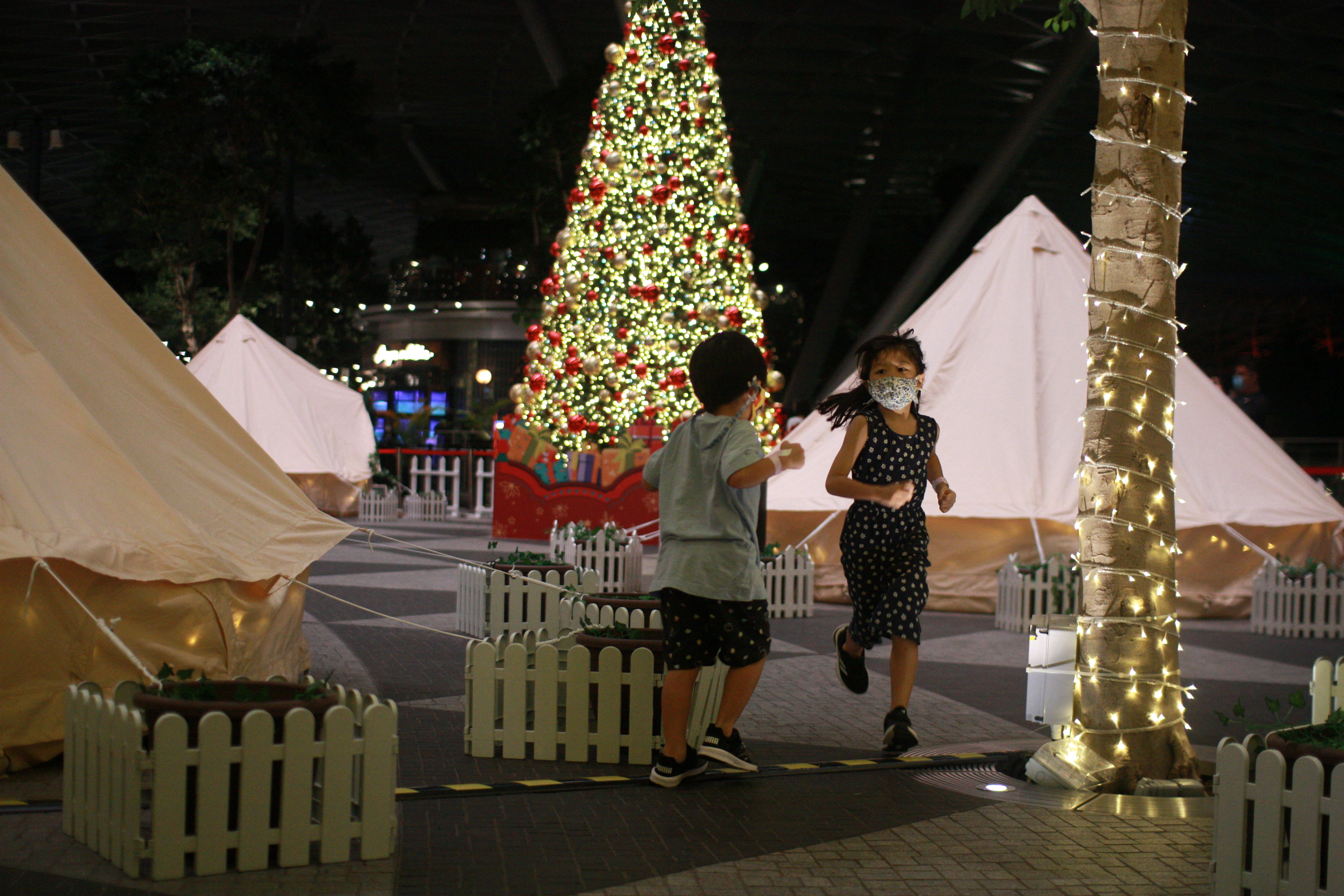 Children play a game of tag at Changi AirportÕs indoor glamping grounds after checking in, in Singapore