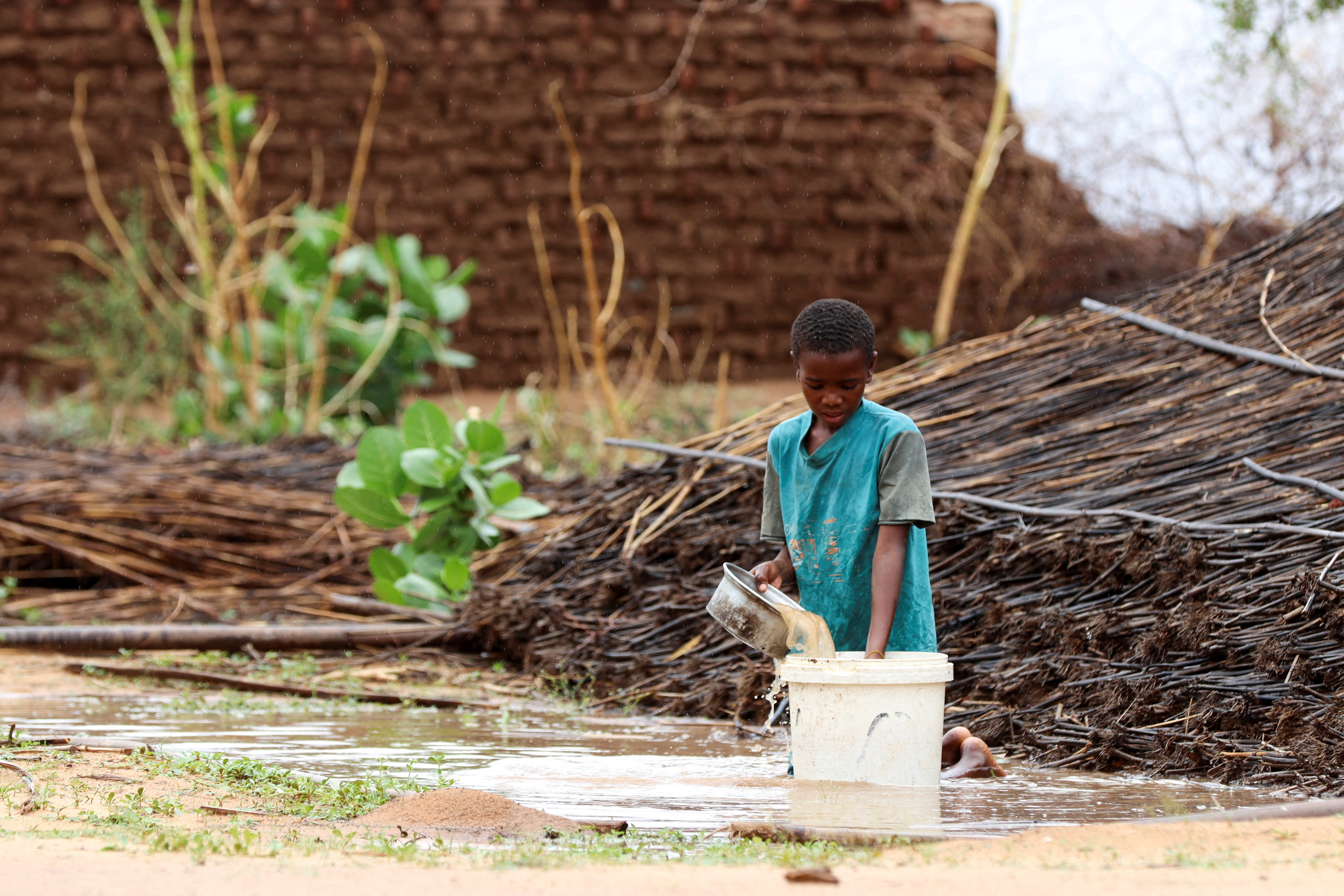 Displaced Sudanese child pours water at Zamzam camp in North Darfur