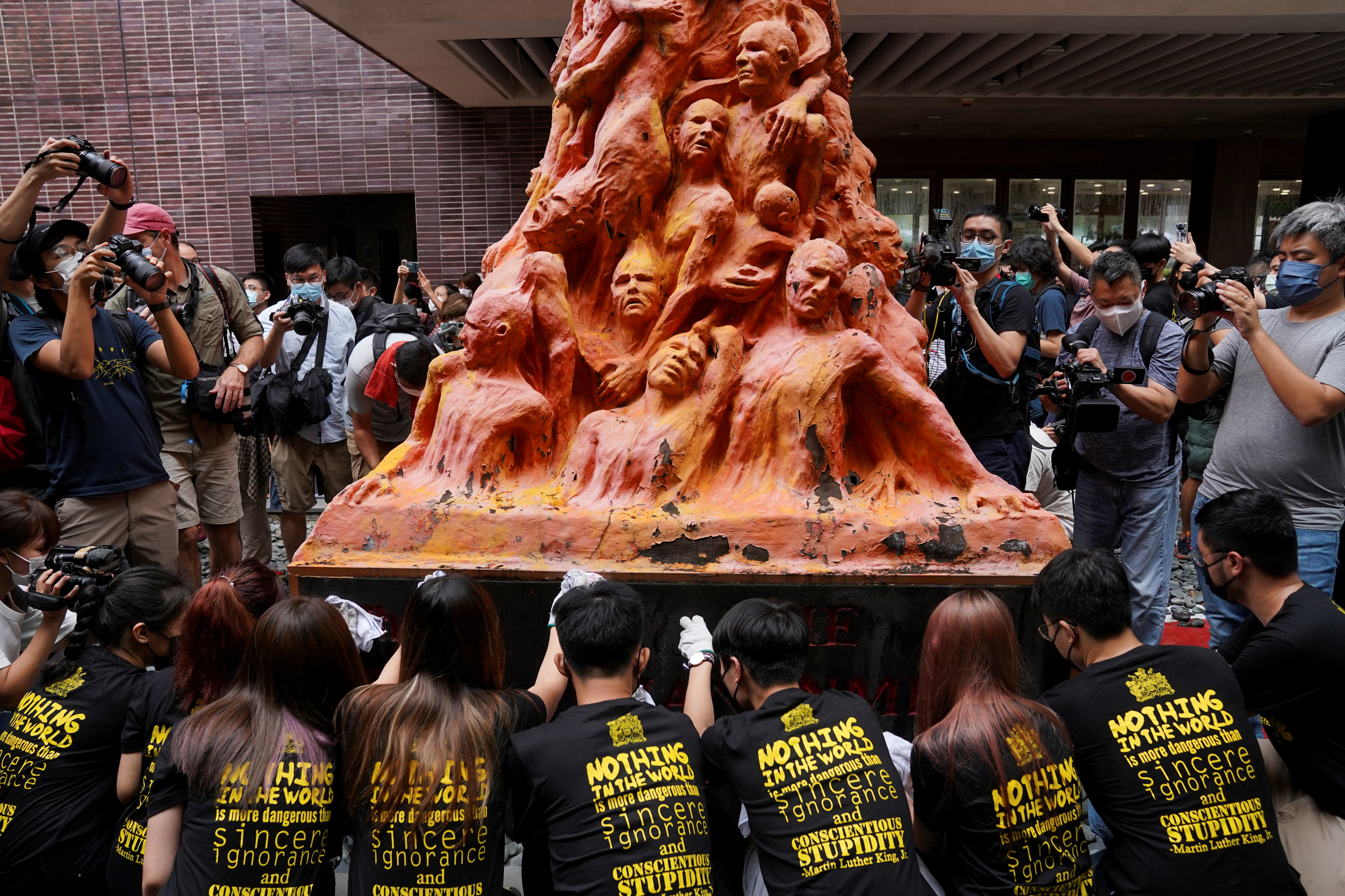 University students clean the "Pillar of Shame" statue at the University of Hong Kong on the 32nd anniversary of the crackdown on pro-democracy demonstrators at Beijing's Tiananmen Square in 1989, in Hong Kong, China June 4, 2021. REUTERS/Lam Yik     TPX IMAGES OF THE DAY