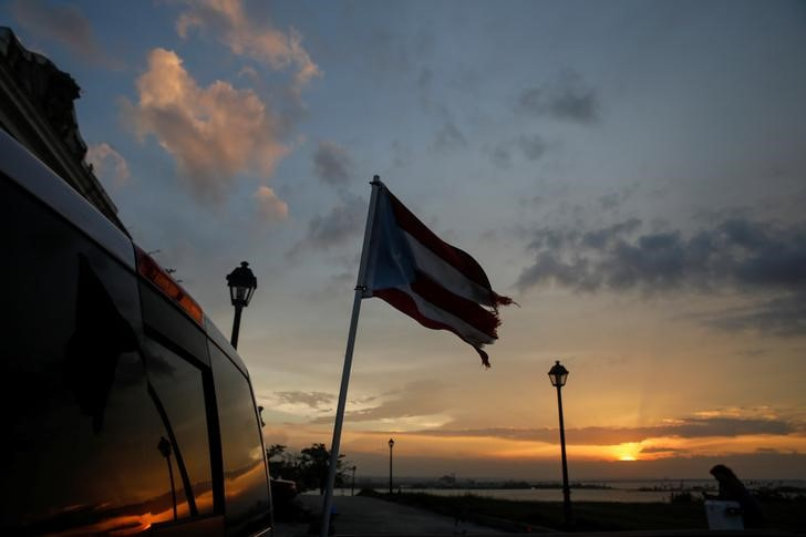 A tattered flag of Puerto Rico flies from a truck parked in the Hurricane Maria affected area of Old San Juan