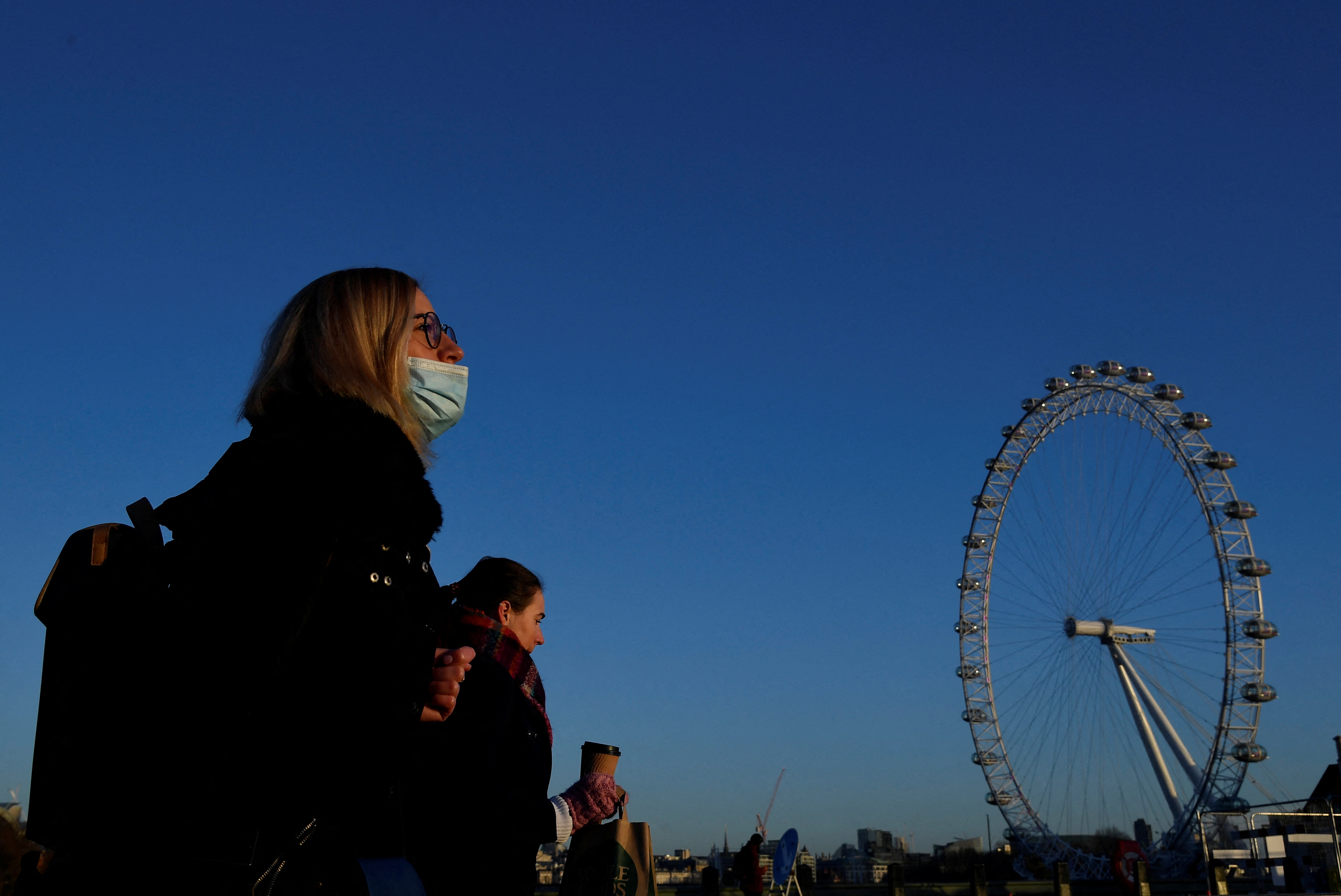 Woman wearing a face mask crosses Westminster Bridge in London