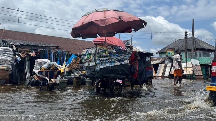 A man pushes a cart through flood water in Yenagoa