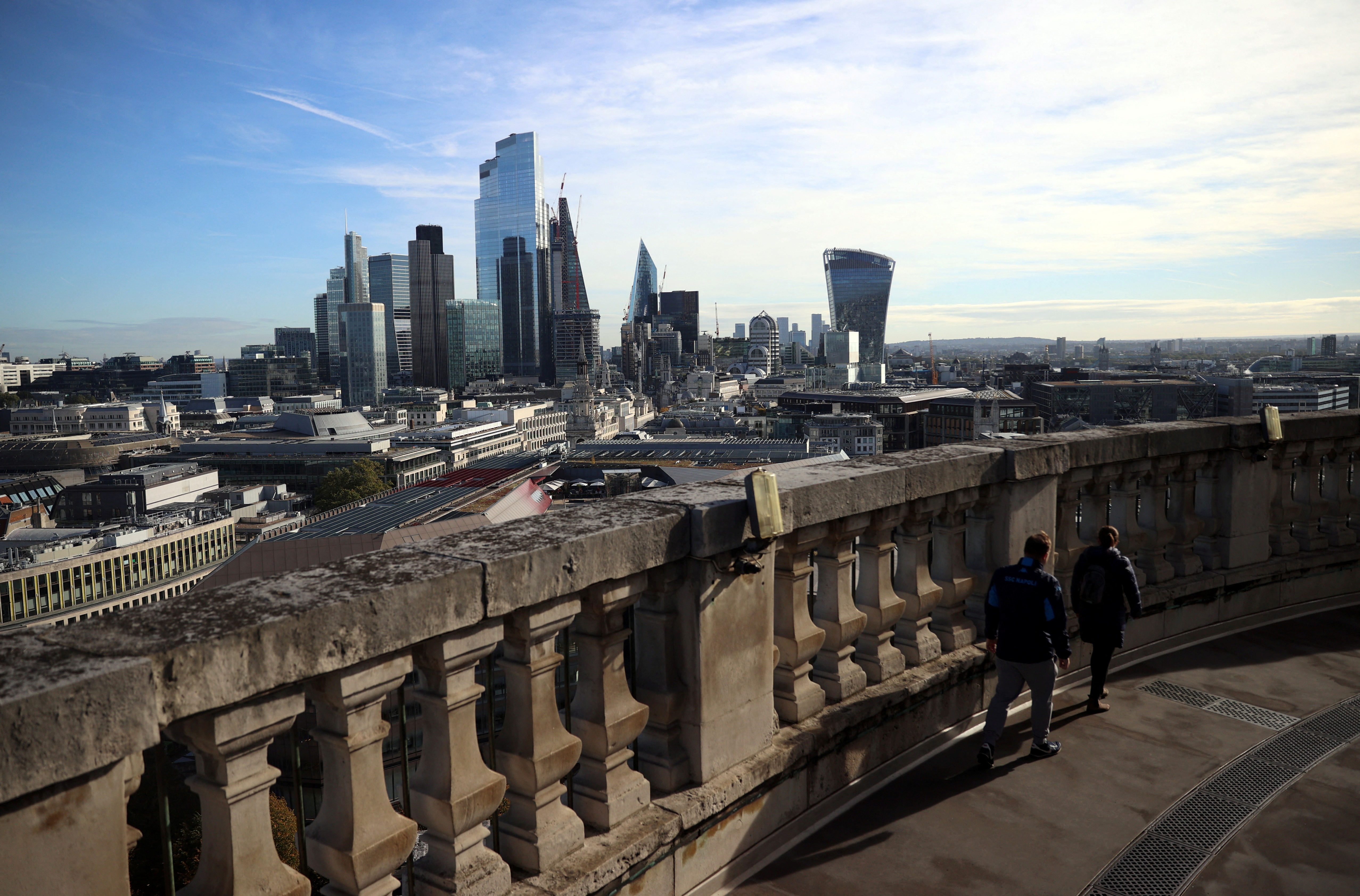 People look out to the City of London financial district from a viewing platform in London, Britain, October 22, 2021. REUTERS/Hannah McKay