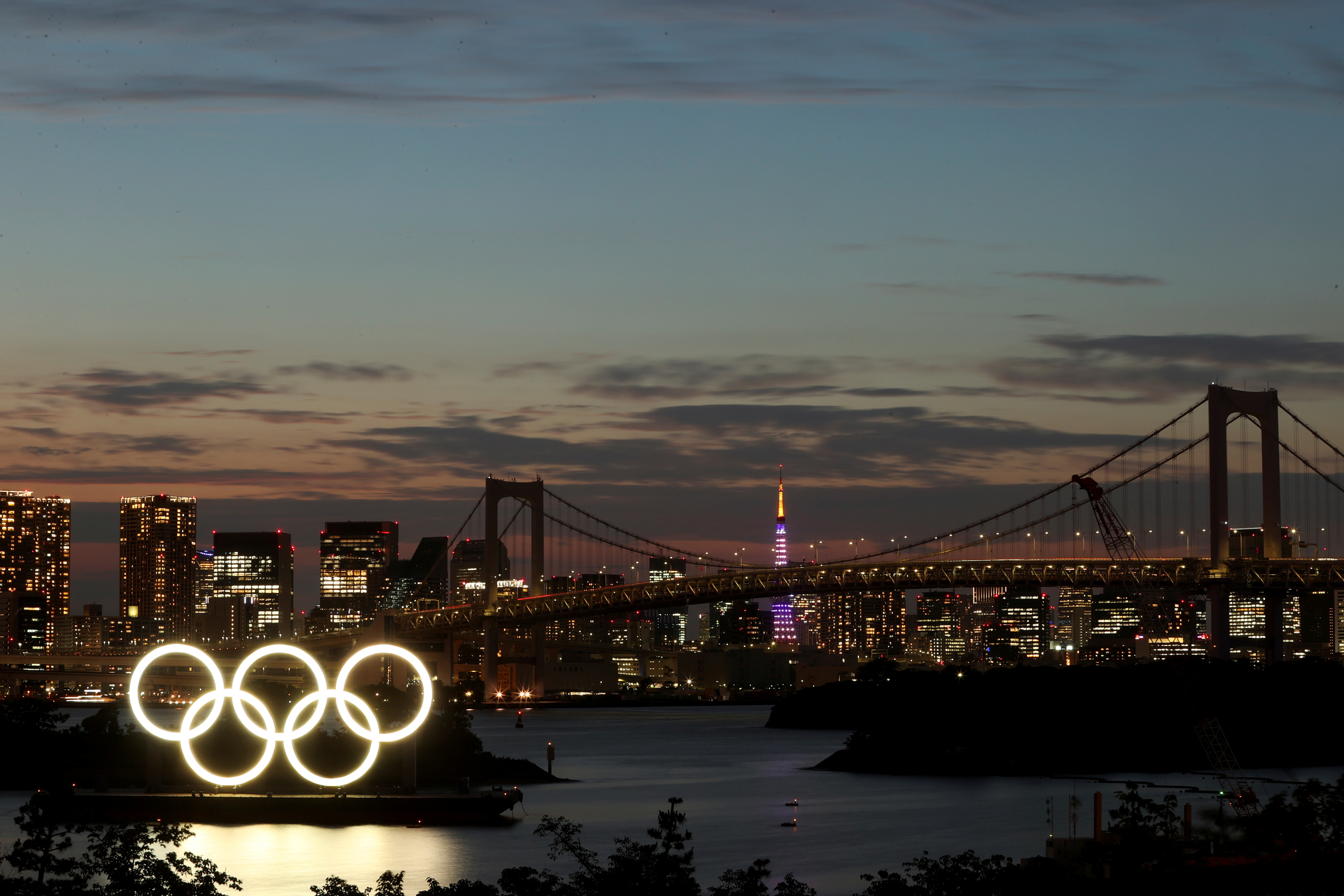 A general view of the Olympic Rings installed on a floating platform with the Rainbow Bridge in the background in preparation for the Tokyo 2020 Olympic Games in Tokyo