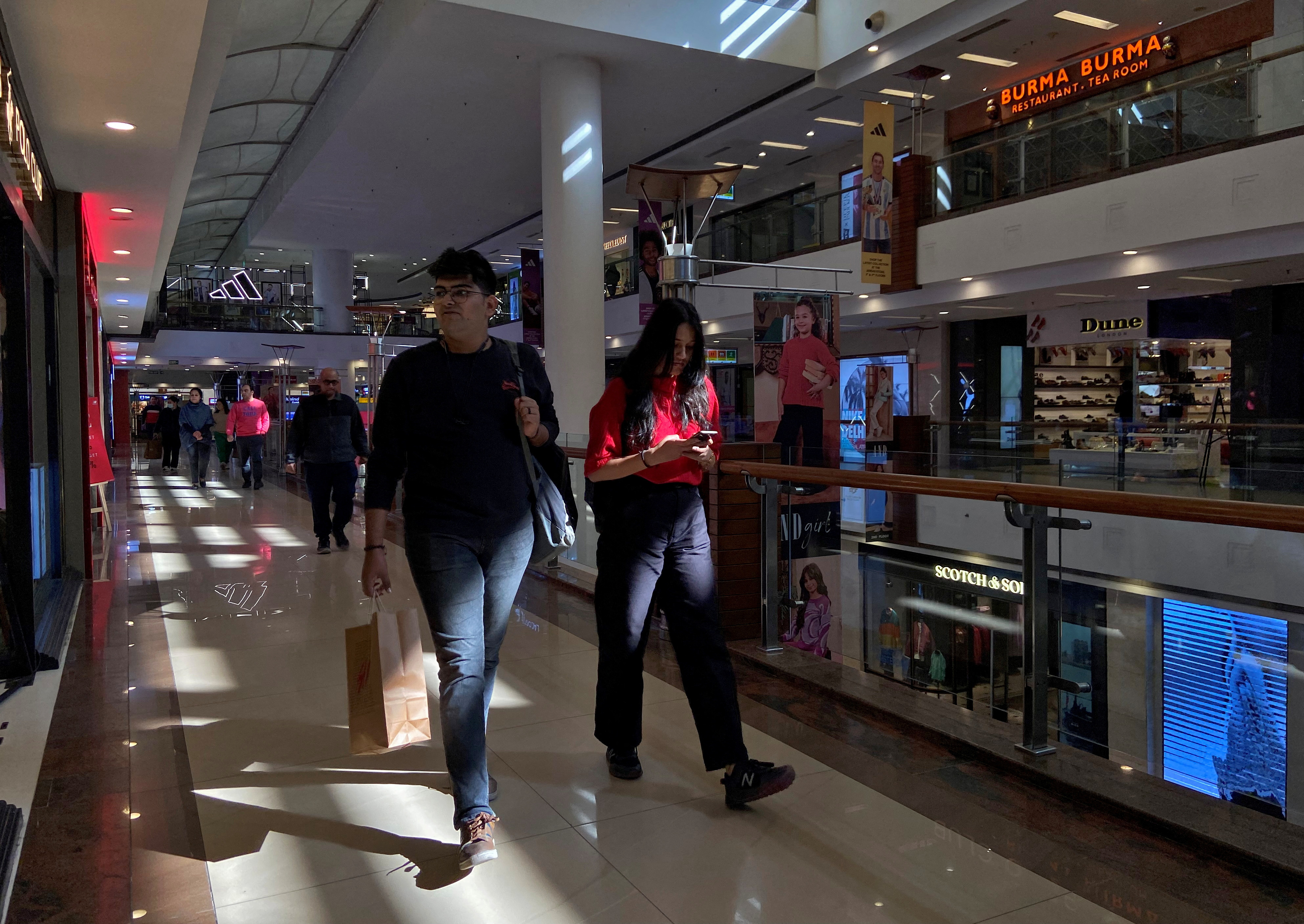 Shoppers walk inside a shopping mall in New Delhi