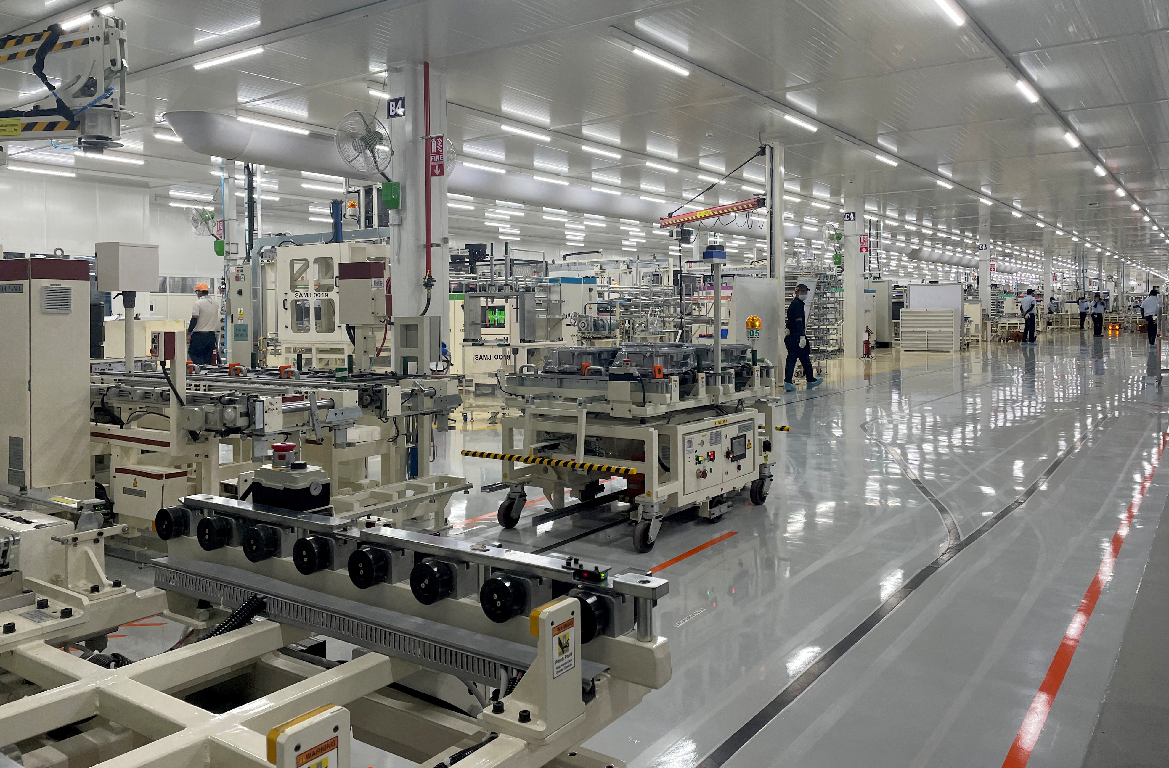 Employees work inside a Toyota Kirloskar Auto Parts factory in Bidadi