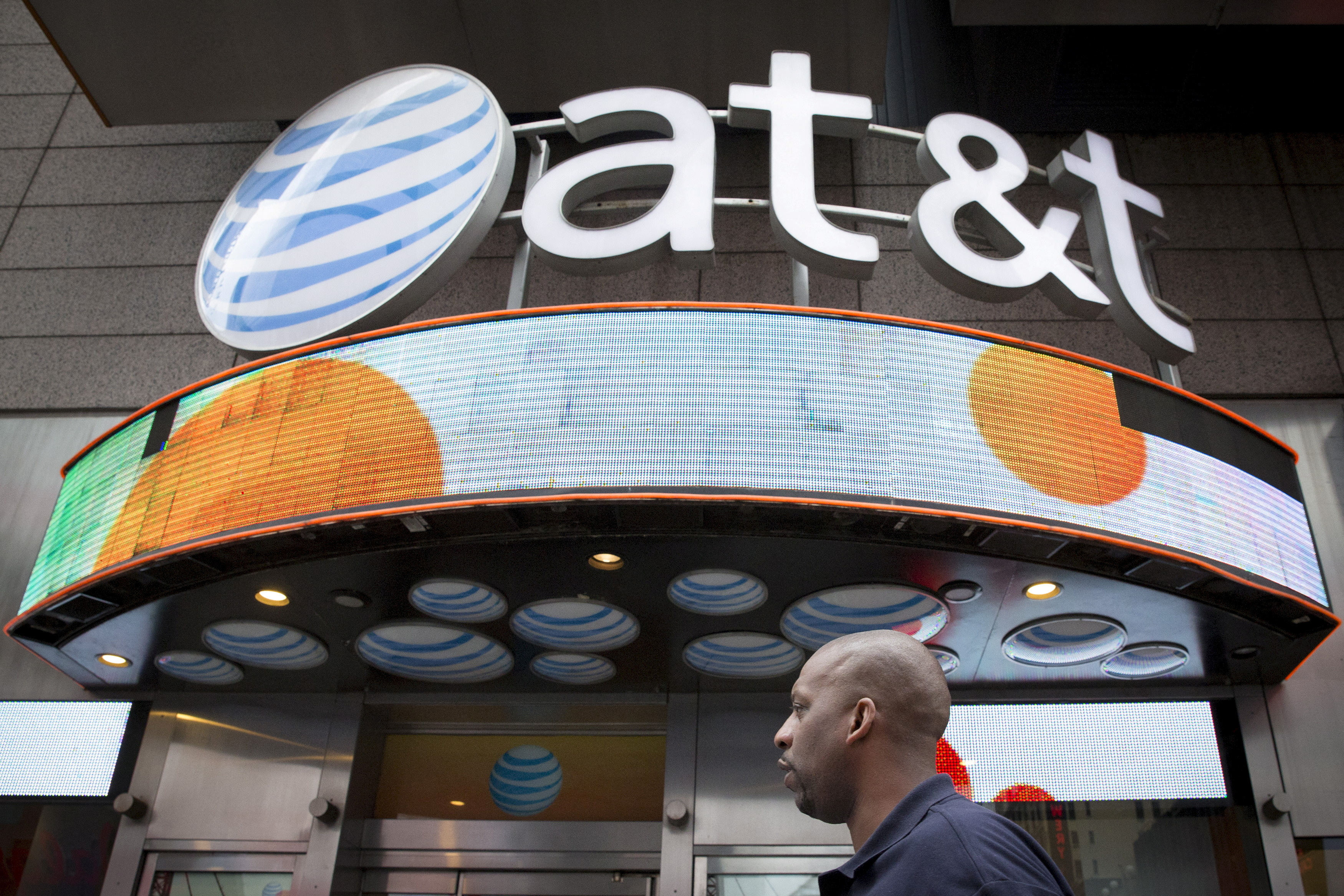 A man walks past the AT&T store in New York's Times Square