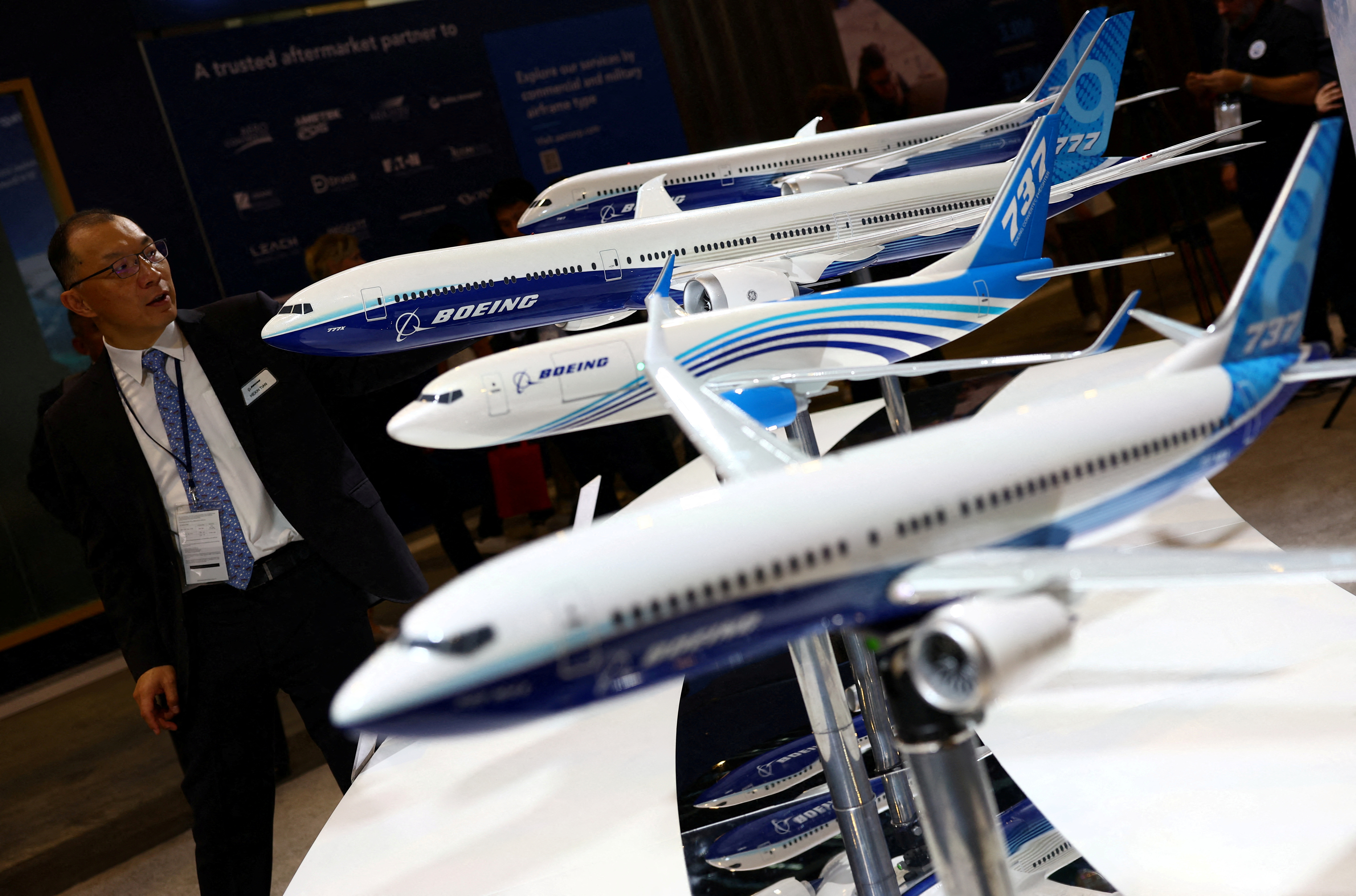 A man passes Boeing model planes on display at the Singapore Airshow at Changi Exhibition Centre in Singapore
