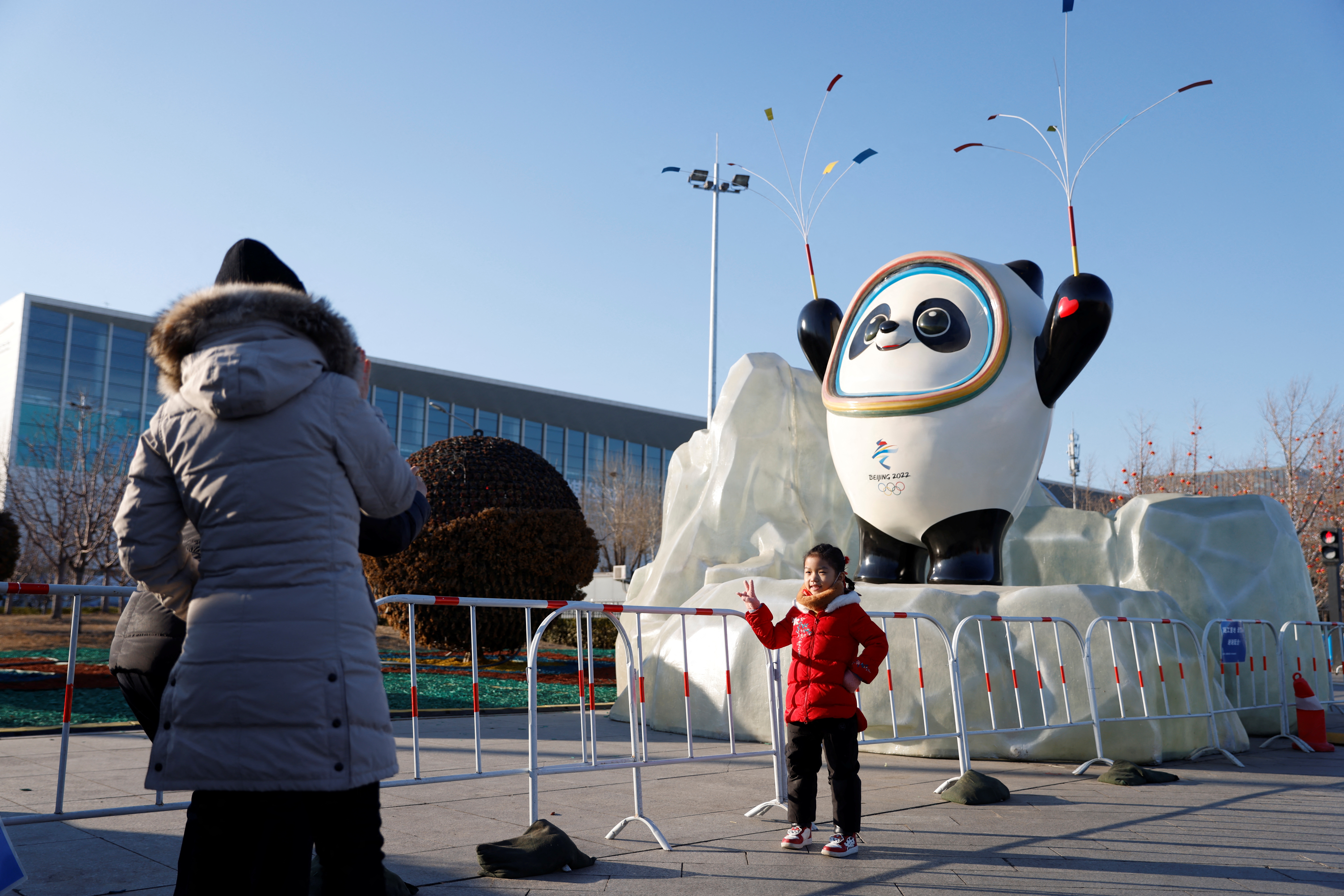 Child poses for pictures in front of an installation of Bing Dwen Dwen, the Beijing 2022 Winter Olympic Mascot, in Beijing