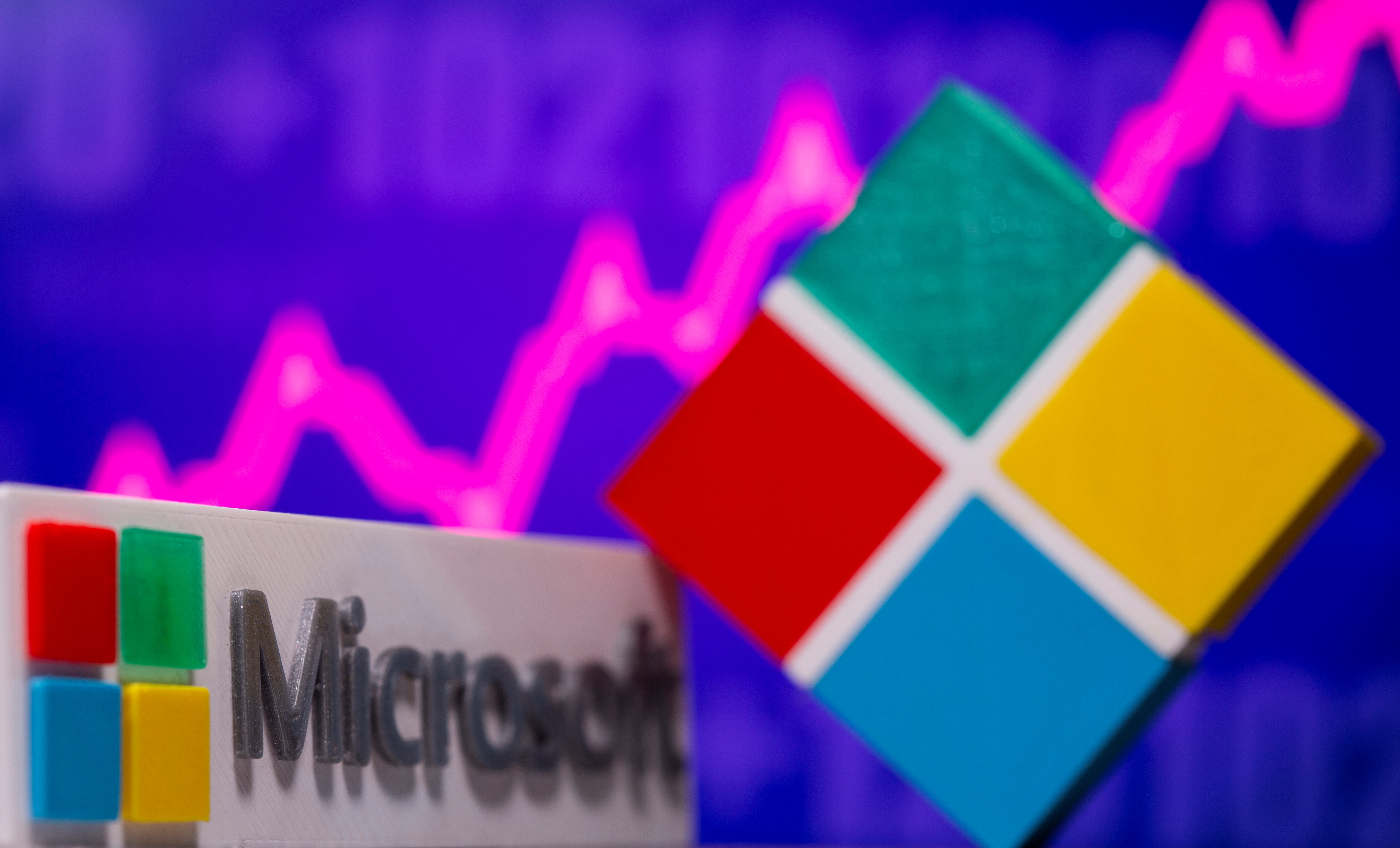 3D-printed Microsoft logos are seen in front of a stock graph in this picture illustration