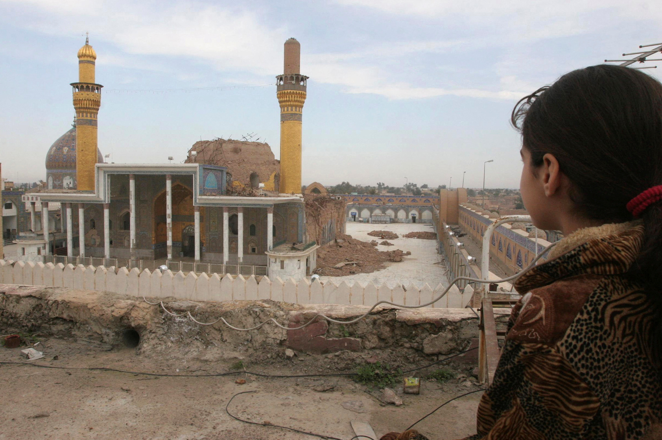 A girl looks at the Golden Mosque which was destroyed in a bomb attack one year ago in Samara