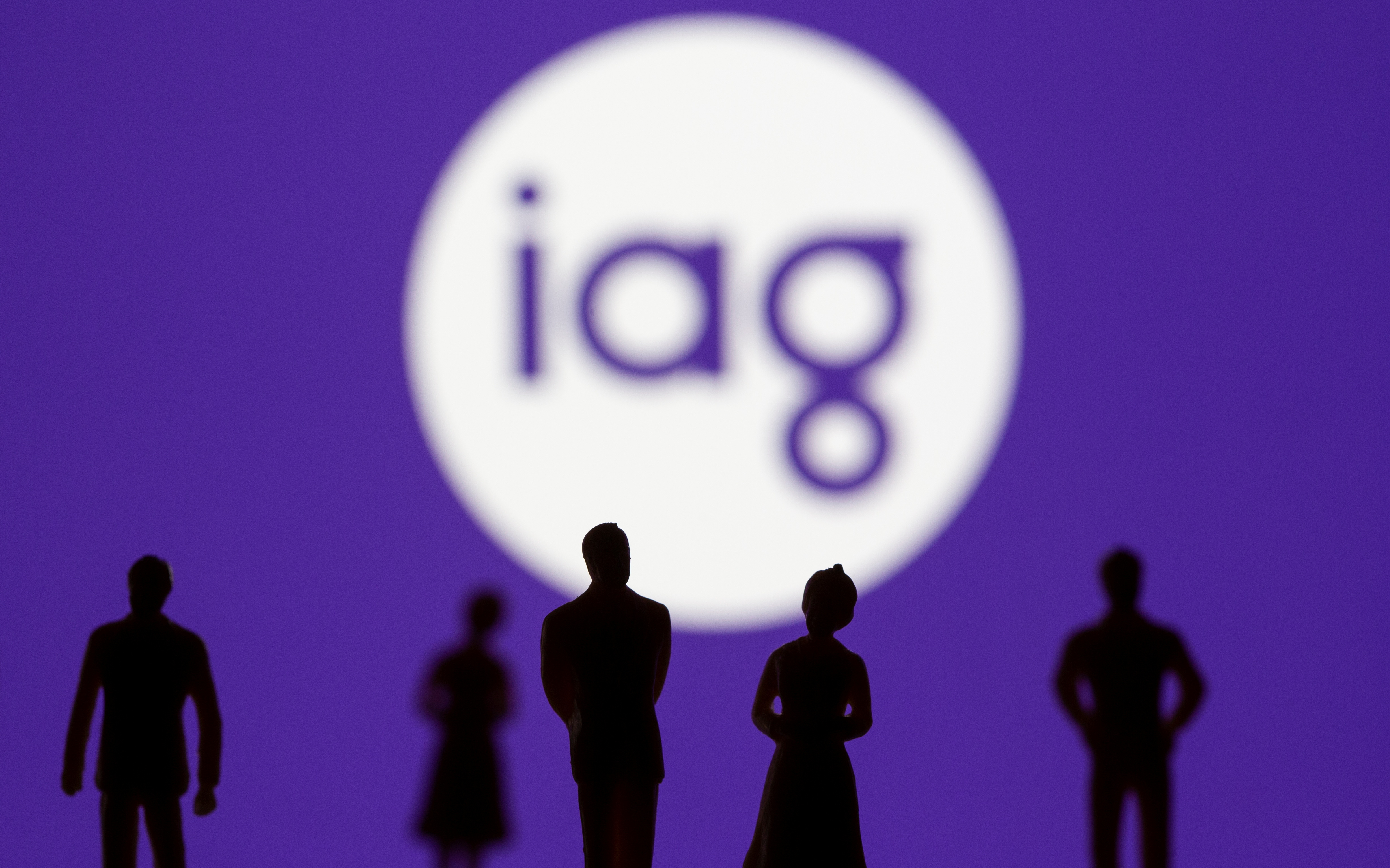 Small toy figures are seen in front of displayed IAG (Insurance Australia Group) logo in this illustration taken