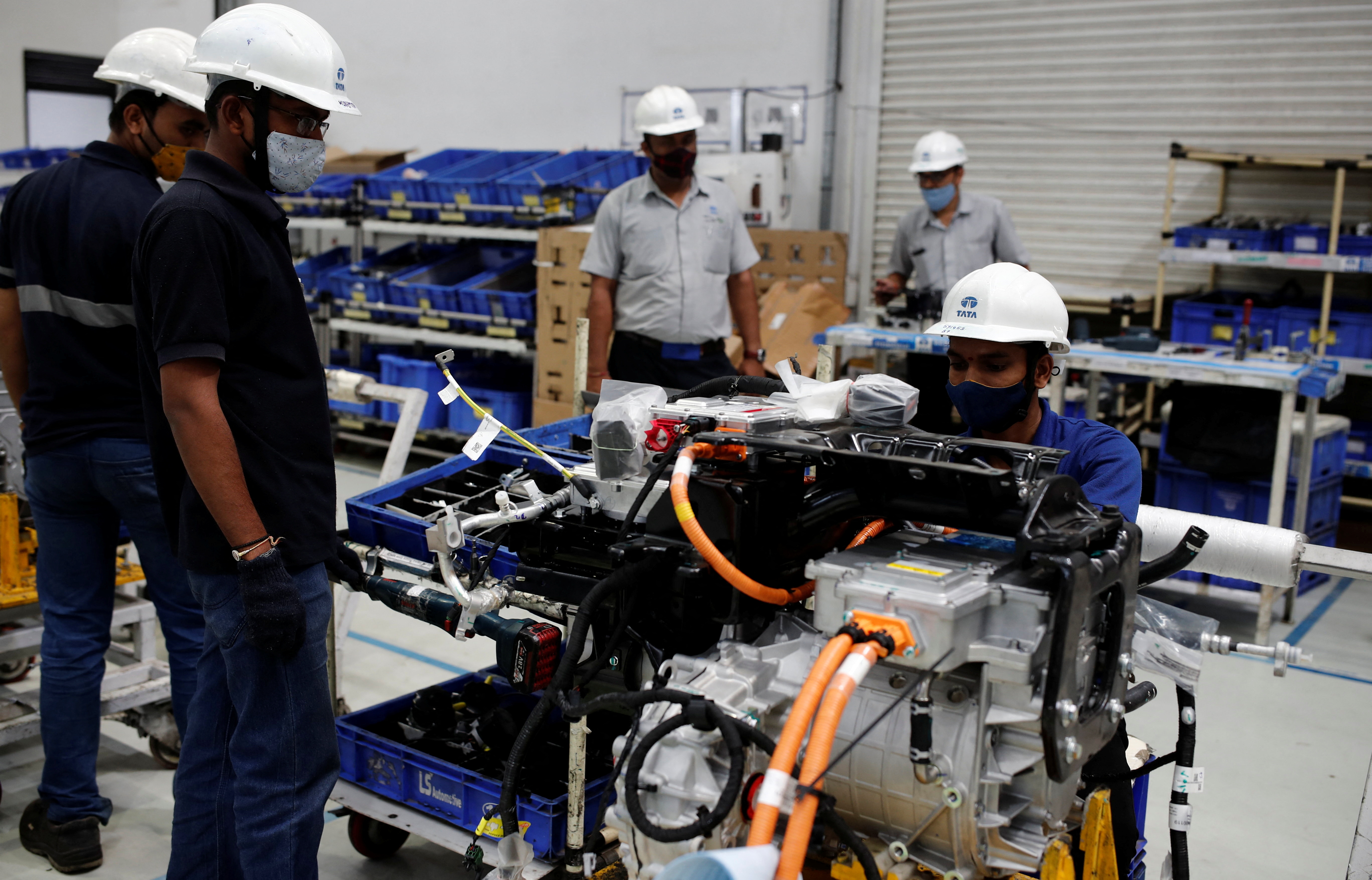 A worker inspects the electric motor before installation inside a Tata Nexon electric sport utility vehicle (SUV)  at the Tata Motors plant in Pune
