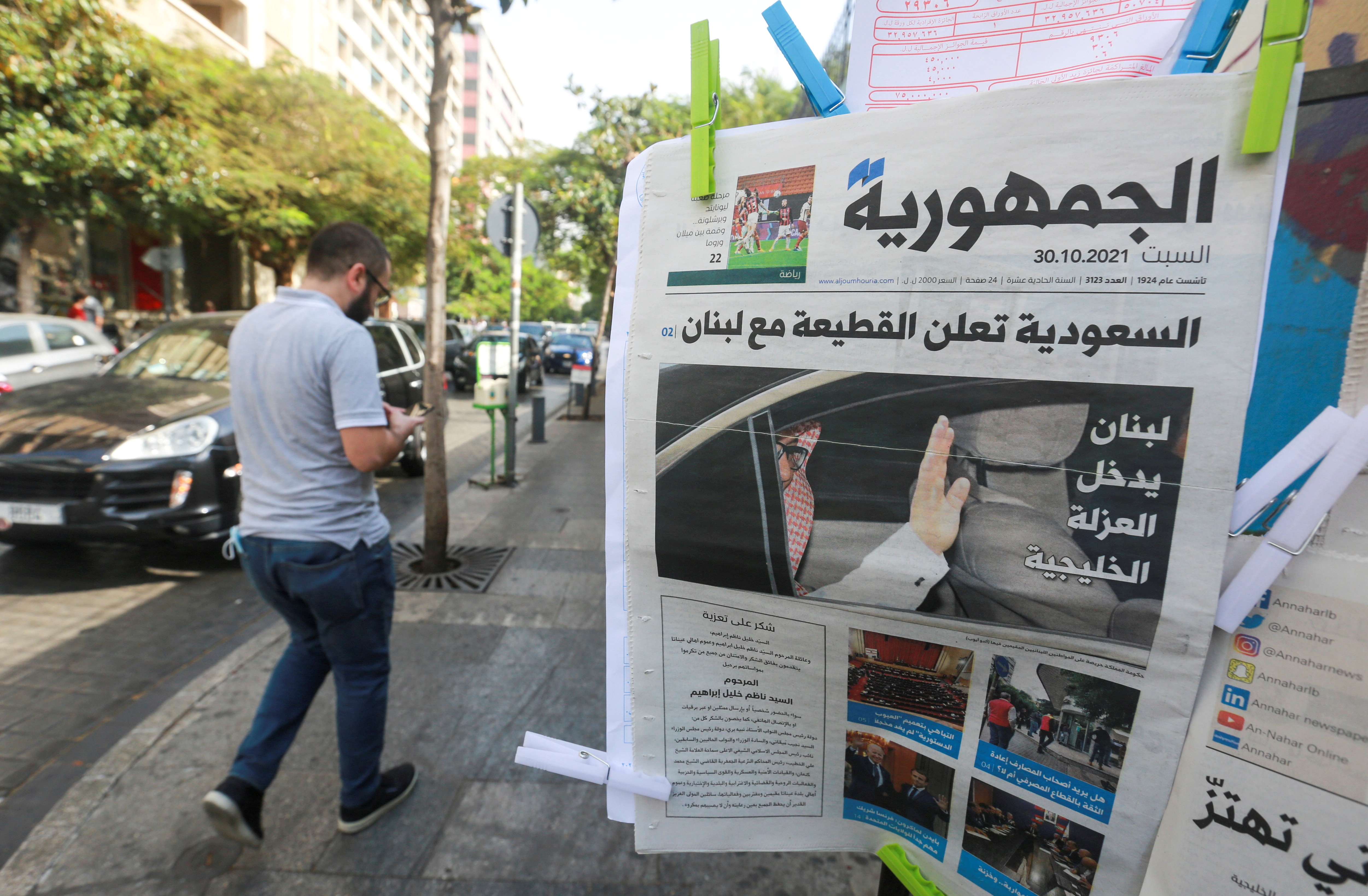 Man walks near a newspaper with a headline that reads " Saudi Arabia announces a boycott with Lebanon" in Beirut