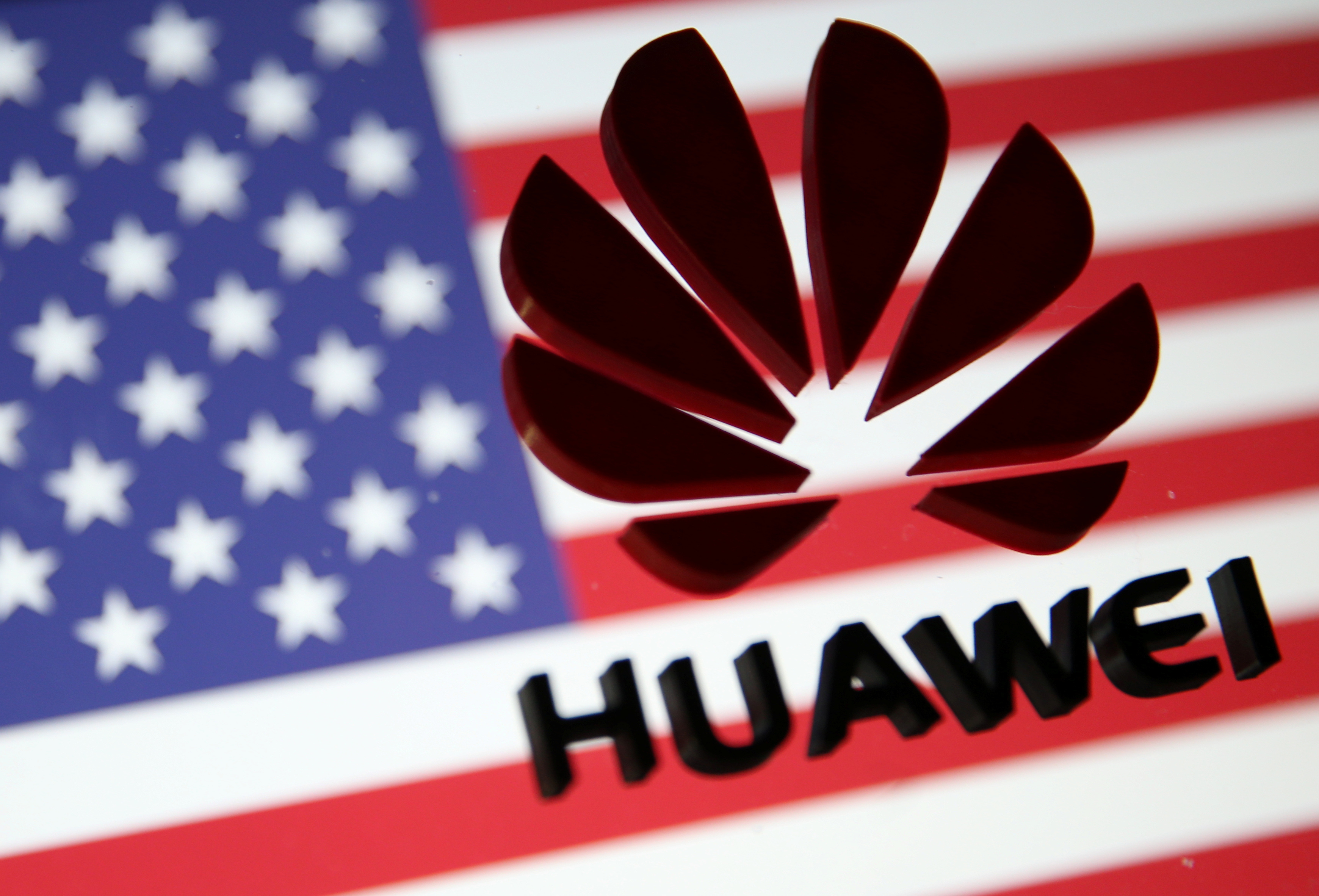 A 3D printed Huawei logo is placed on glass above displayed US flag in this illustration