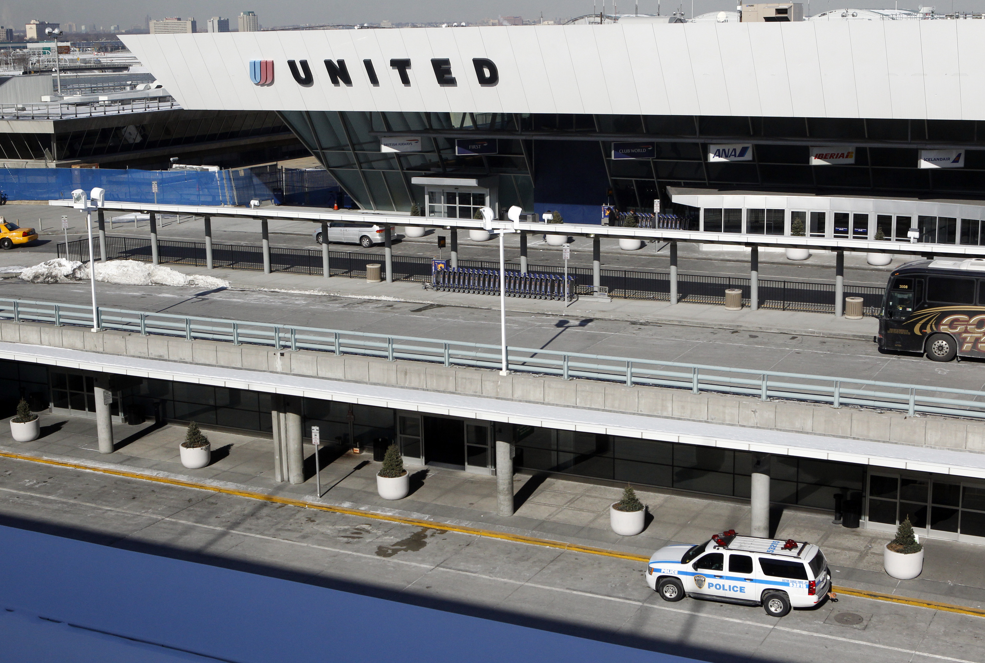 A police vehicle is parked outside a United Airlines terminal at John F. Kennedy International Airport in New York