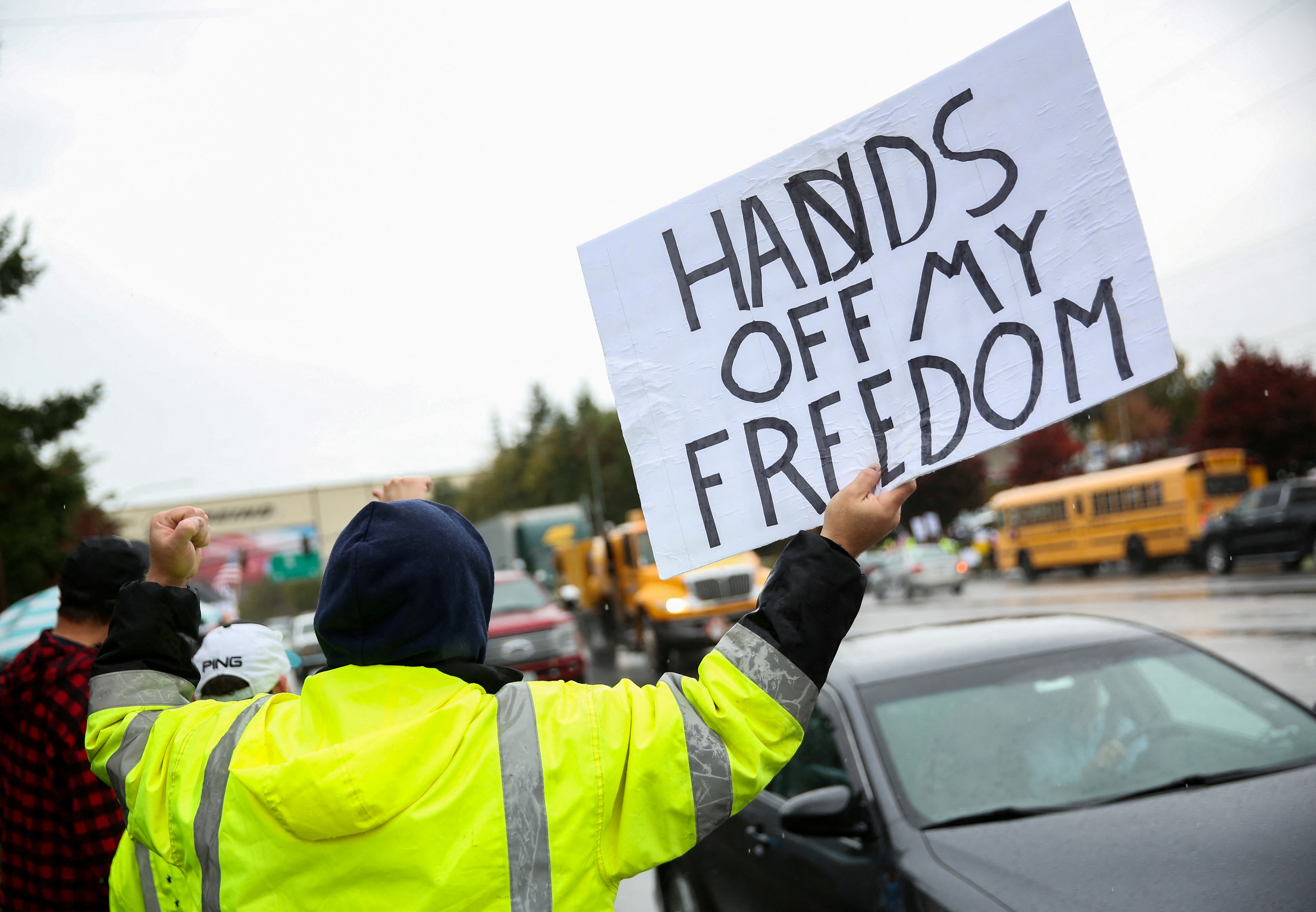Fuori dalla struttura della Boeing a Everett, Washington, il 15 ottobre 2021, un manifestante fa un gesto mentre i dipendenti della Boeing e altri si allineano in strada per protestare contro l'ordine di vaccinazione contro il virus corona (COVID-19) dell'azienda.  REUTERS / Lindsey Wasson
