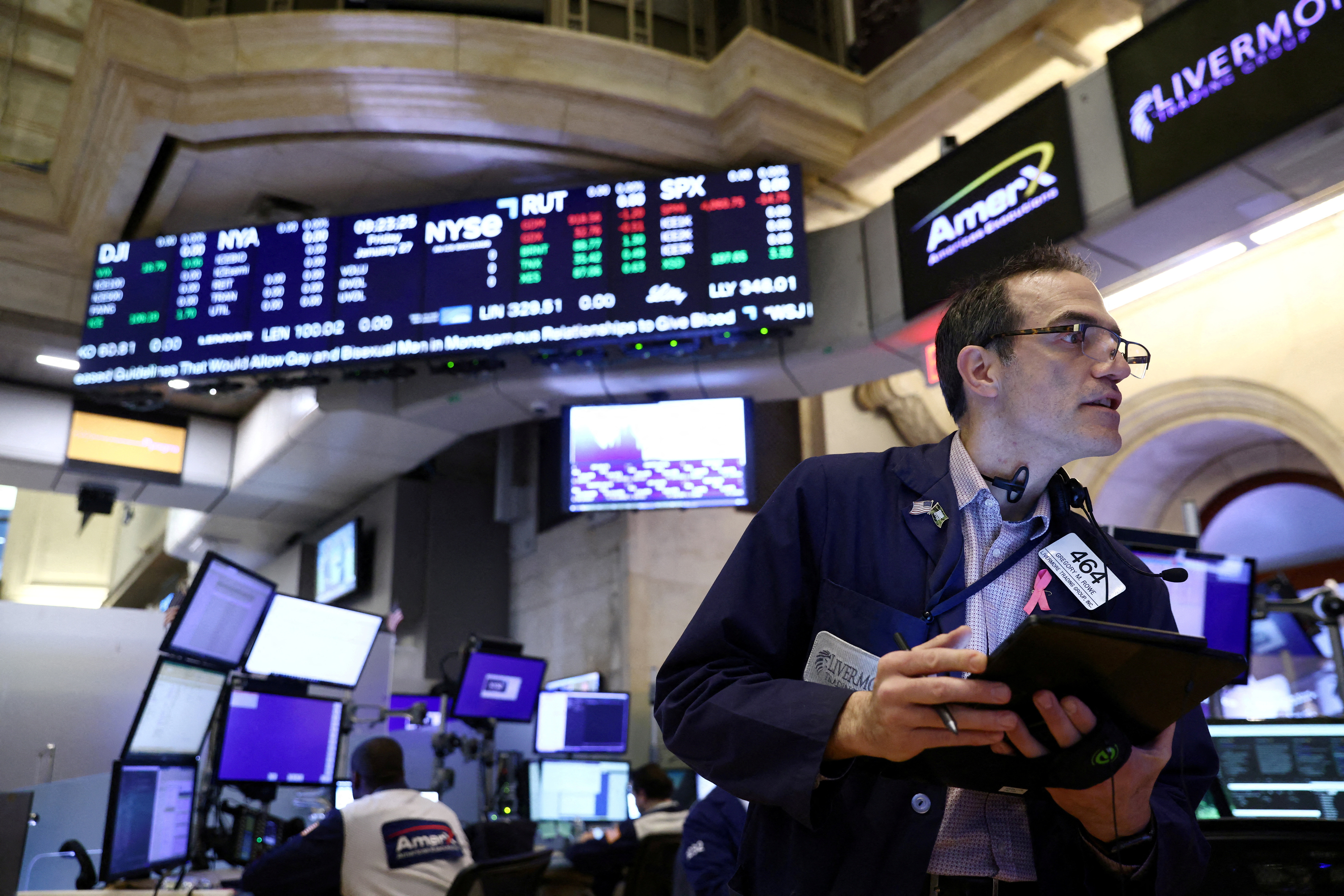 FILE PHOTO: A trader works on the trading floor at the New York Stock Exchange (NYSE) in New York City, U.S.