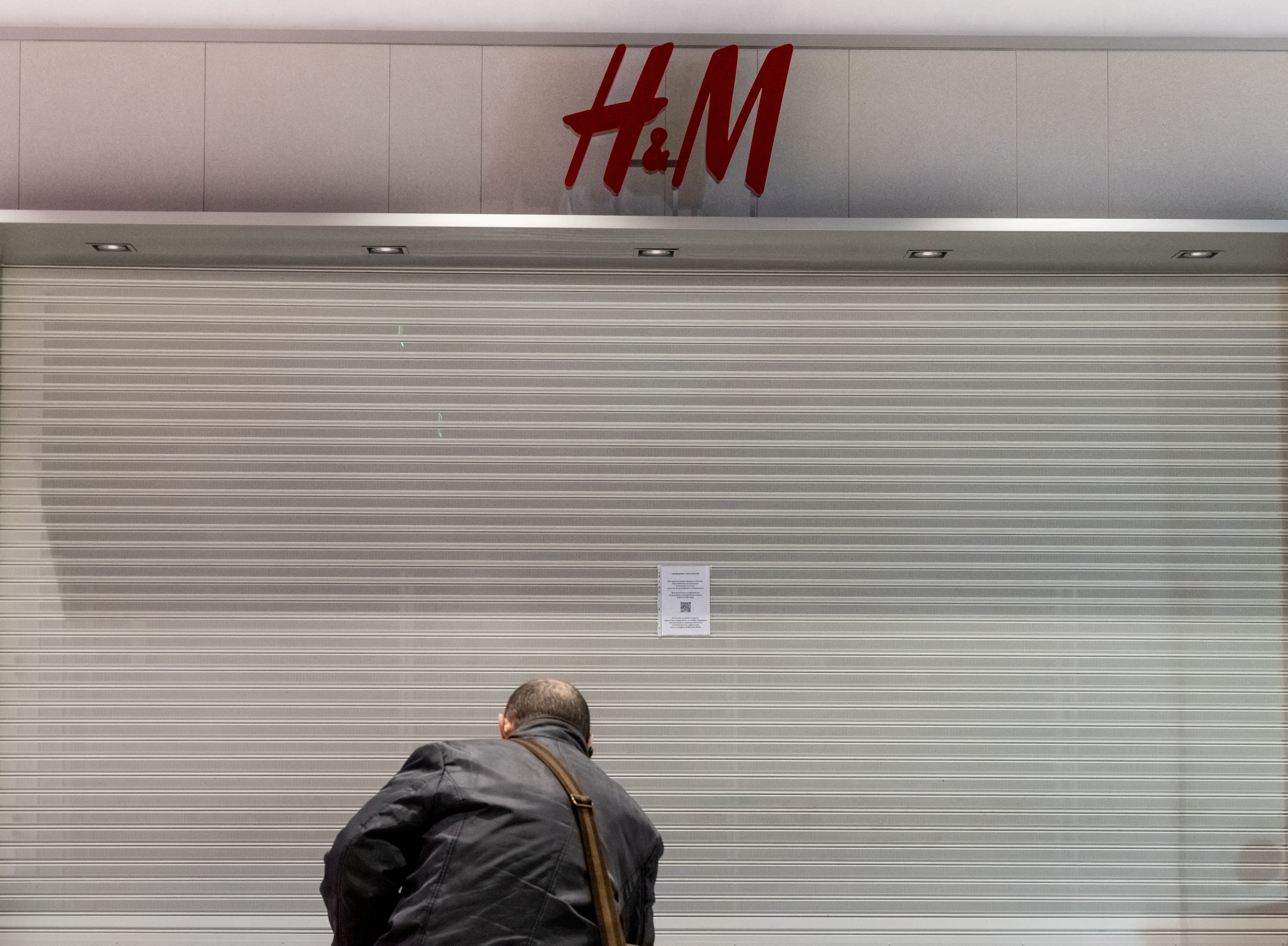 A man looks at a closed H&M store in a shopping mall in Moscow