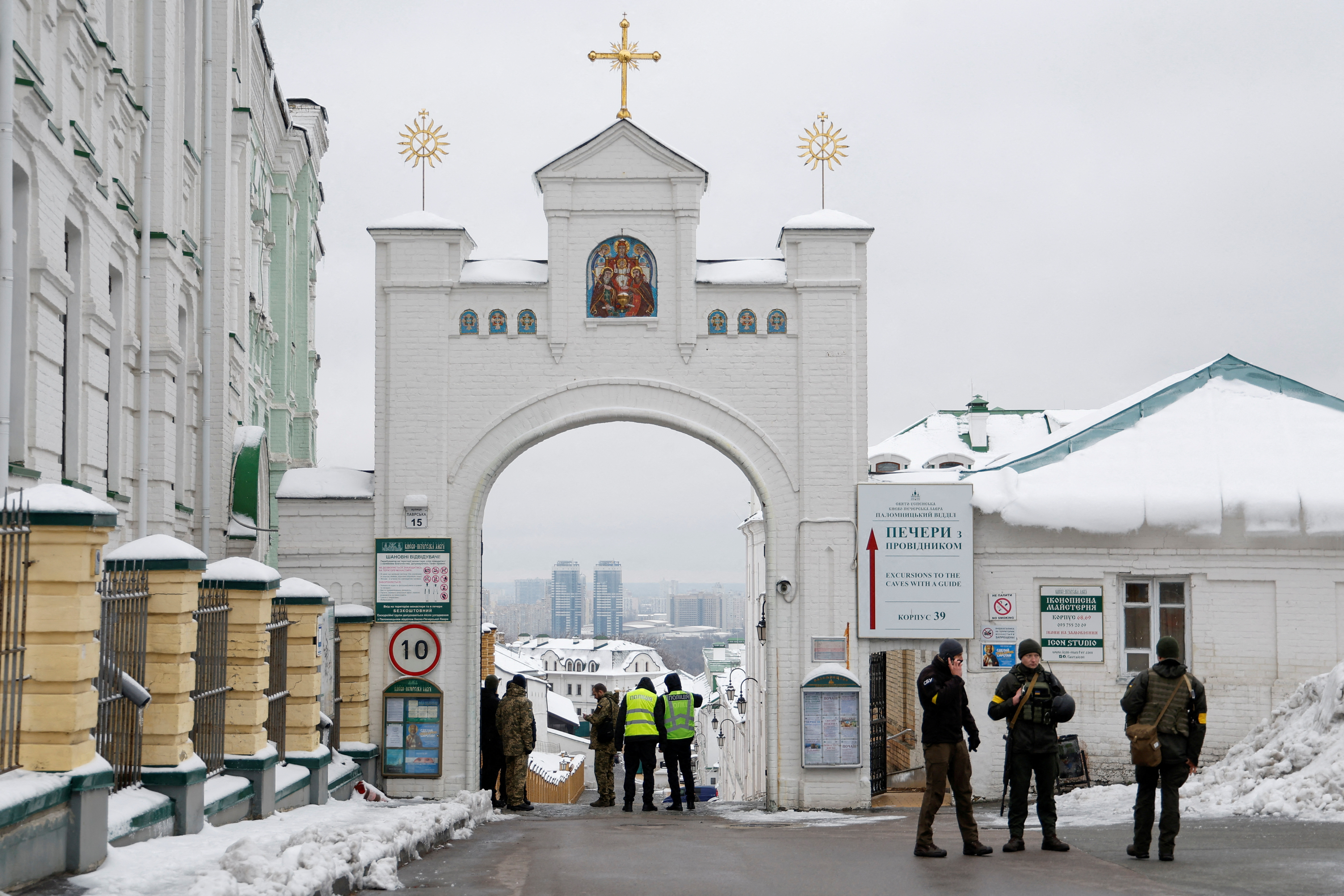 Ukrainian law enforcement officers stand next to an entrance to the Kyiv Pechersk Lavra monastery compound in Kyiv