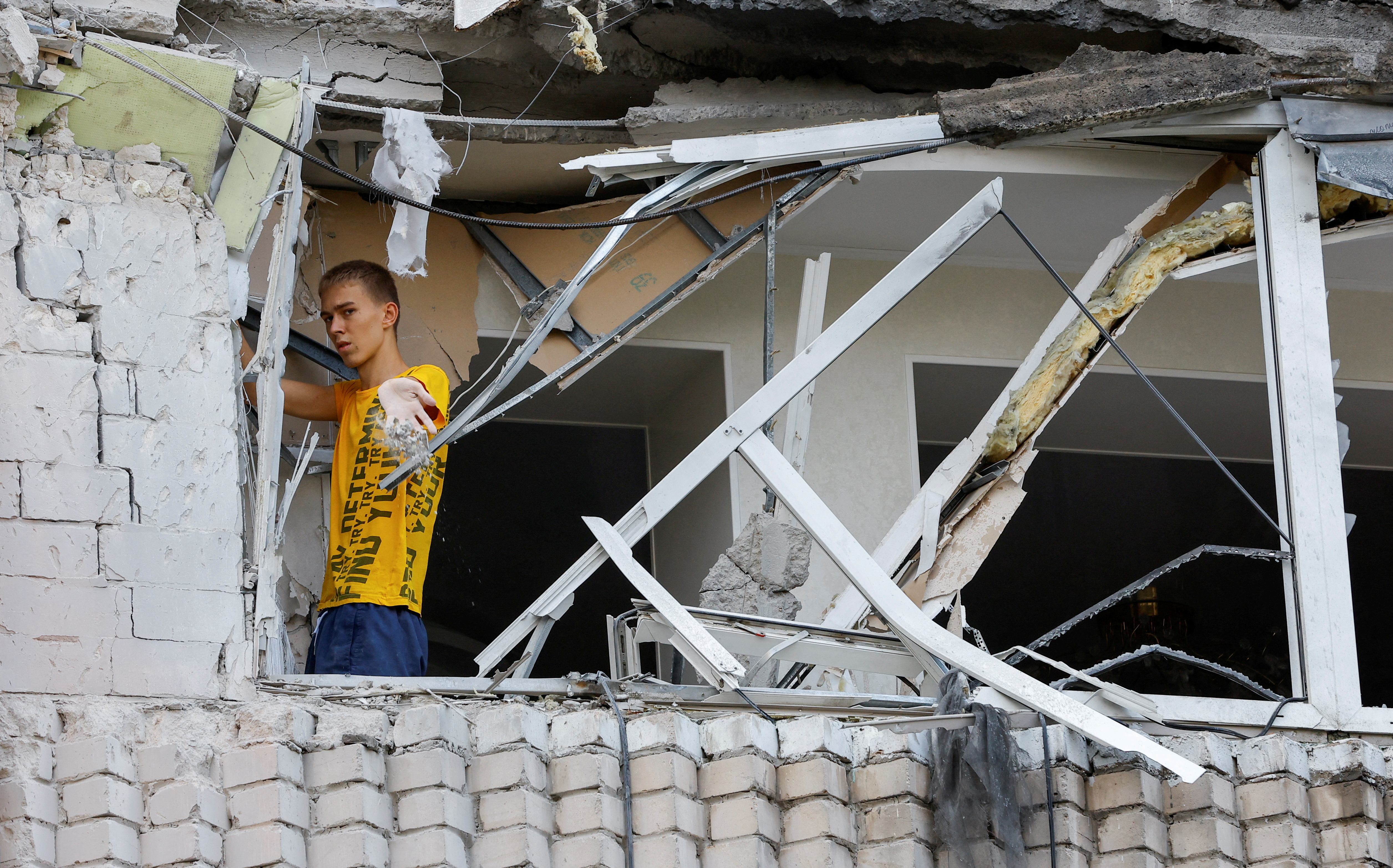 A local resident removes debris following shelling in Enerhodar