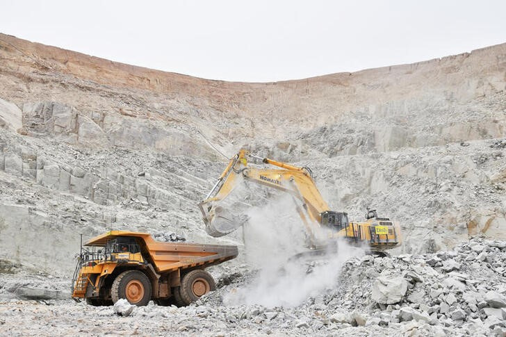 FILE PHOTO: An excavator driven by Rosalie Guirou Kulga, 30, clears out rocks into a dumper at the gold mine, operated by Endeavour Mining Corporation in Hounde