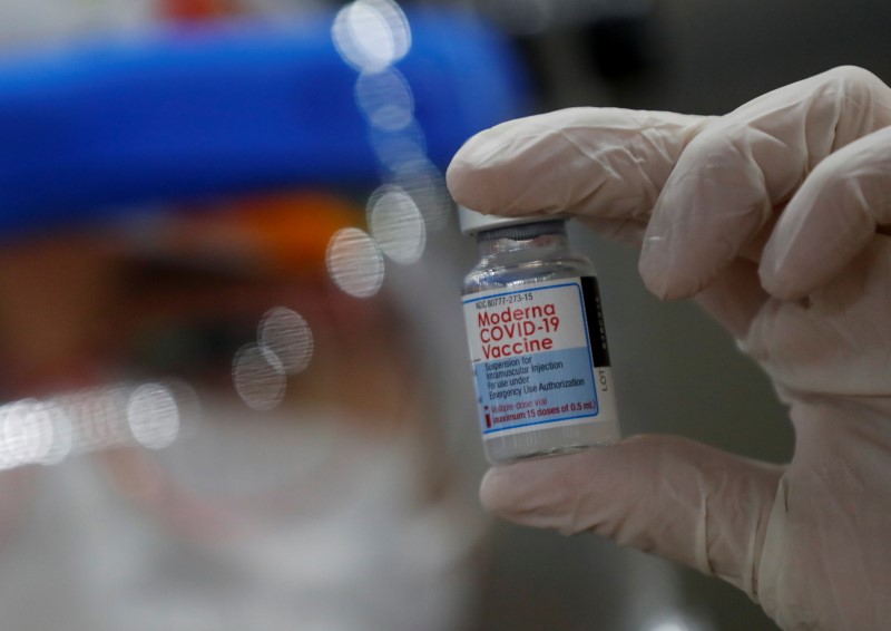 Health worker Carla Diaz holds a vial of the Moderna vaccine against the coronavirus disease (COVID-19) at a vaccination center in Buenos Aires, Argentina August 9, 2021. REUTERS/Agustin Marcarian