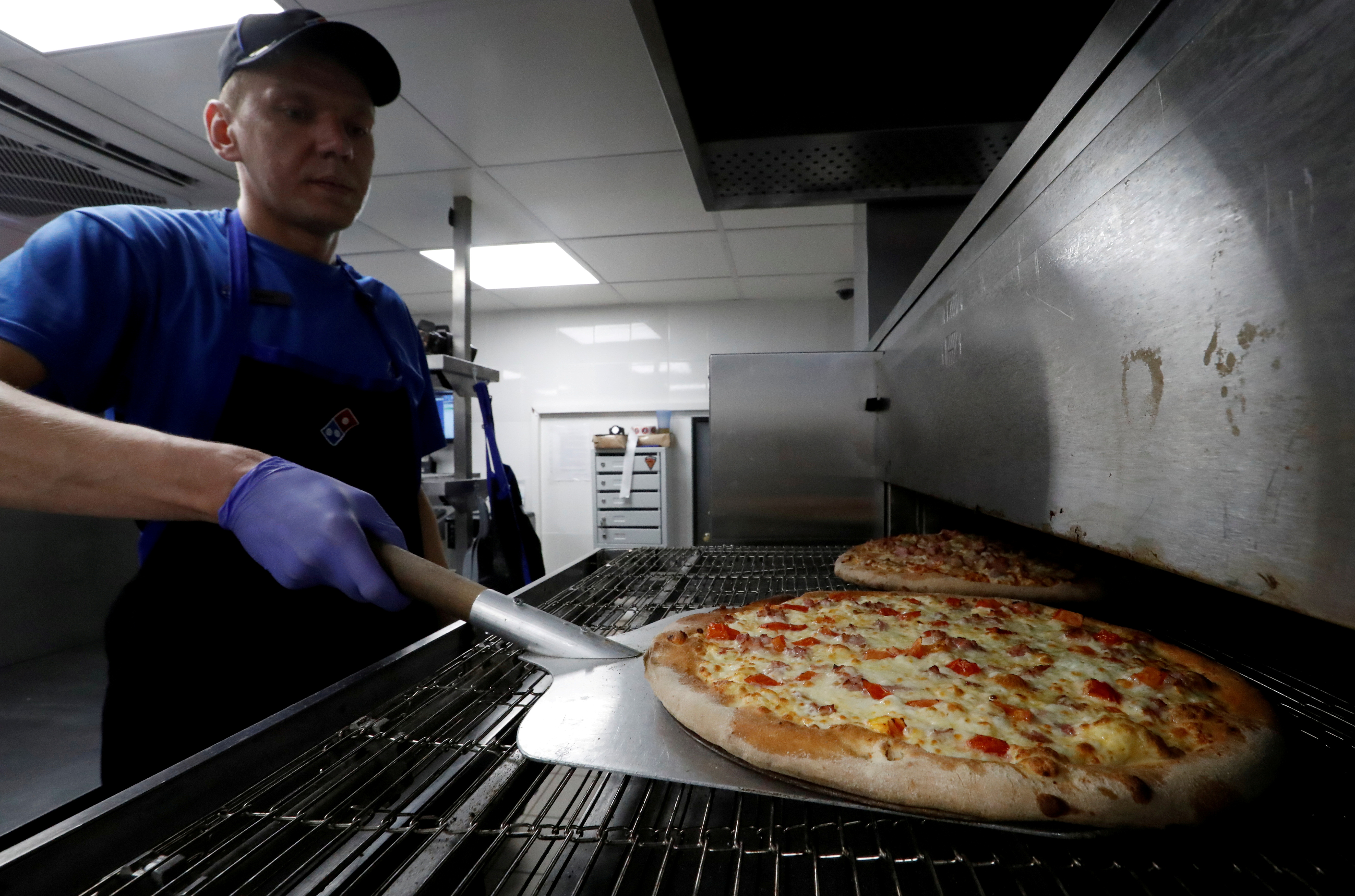 A staff member prepares pizzas at a Domino's Pizza restaurant in Moscow, Russia