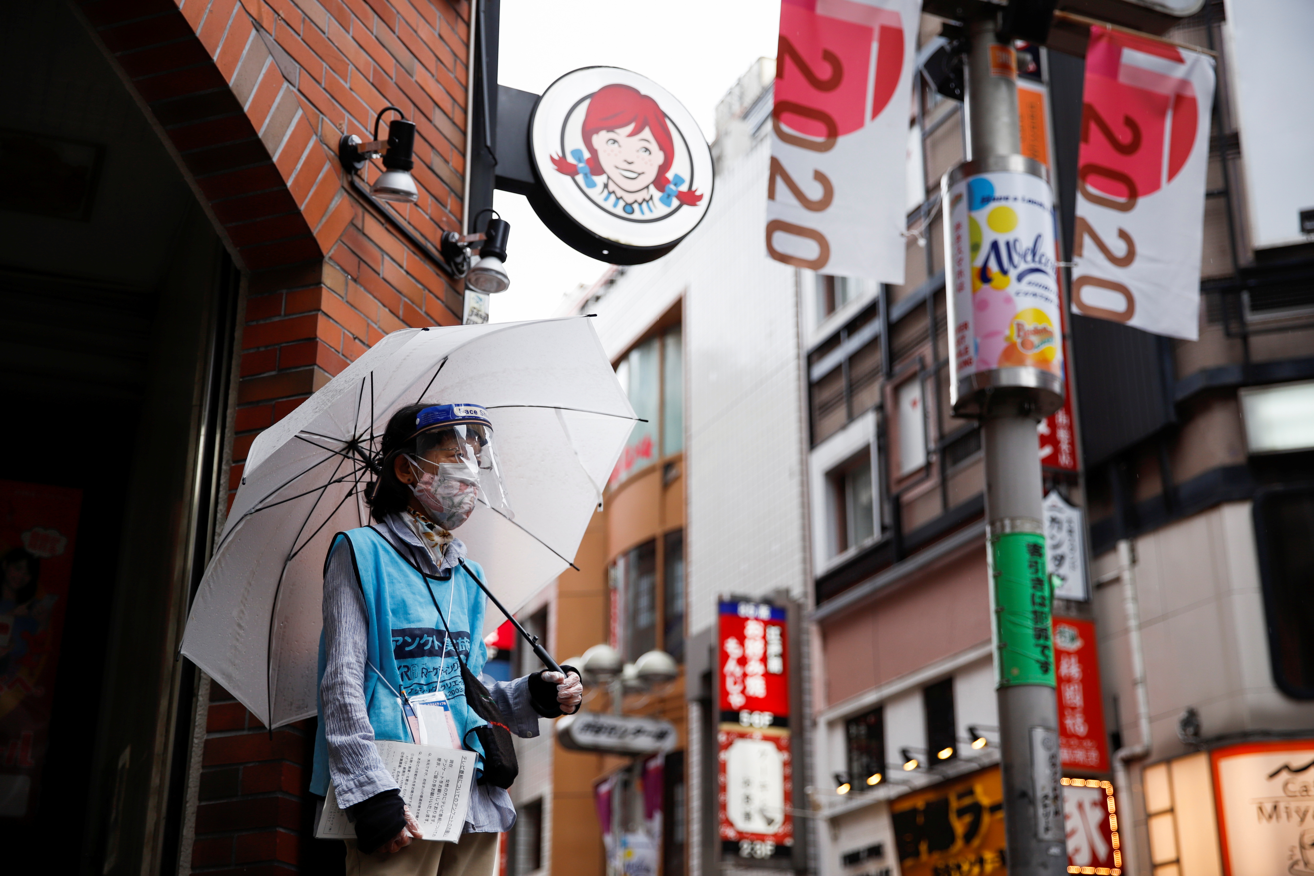 Woman who does street surveys wears a mask and a face shield, during a state of emergency amid the coronavirus disease (COVID-19) outbreak, in Tokyo, Japan August 29, 2021. REUTERS/Androniki Christodoulou
