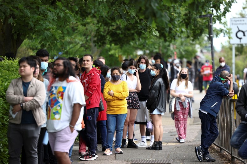 nePeople queue outside a vaccination centre for those aged over 18 at the Belmont Health Centre in Harrow, amid the coronavirus disease (COVID-19) outbreak, in London